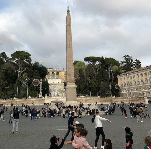 Children chase bubbles in Piazza del Popolo in Rome.