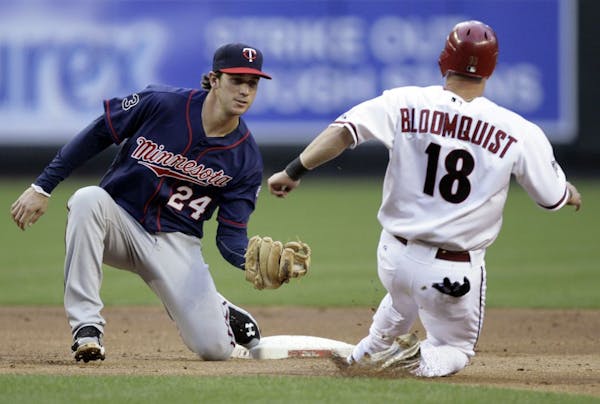 Twins shortstop Trevor Plouffe (left) prepared to tag out the Diamondbacks' Willie Bloomquist on a steal attempt in the first inning Friday.