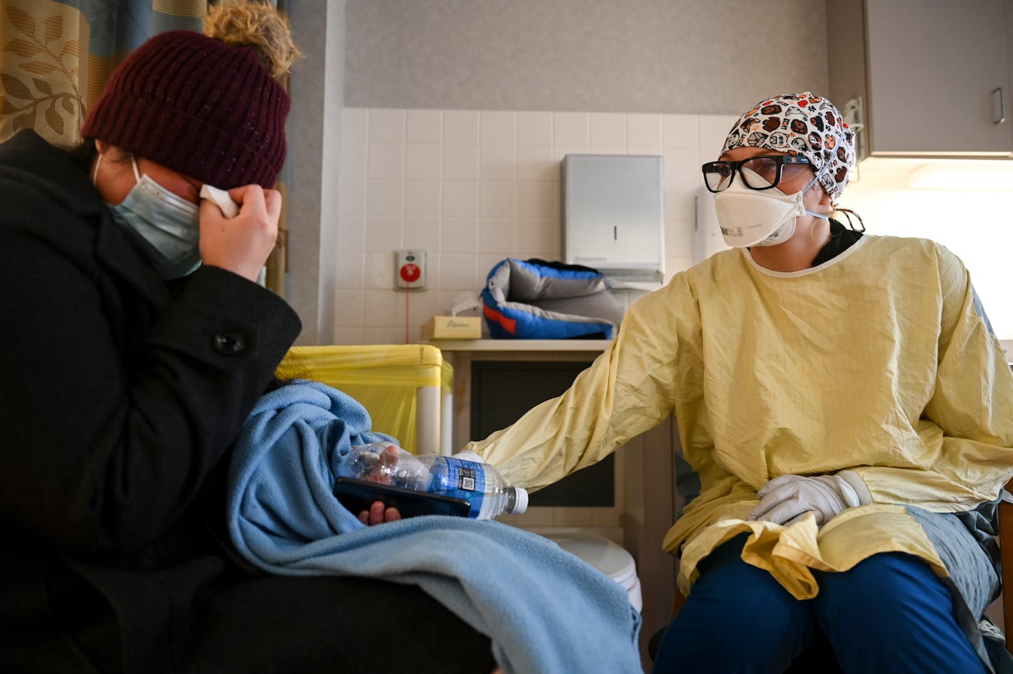 Heidi Hartmann, a float nurse working North Memorial's South Seven Intensive Care Unit in December, comforted Katie Ogundepo, whose mother's organs are failing as she lay intubated in the ICU while battling COVID-19.