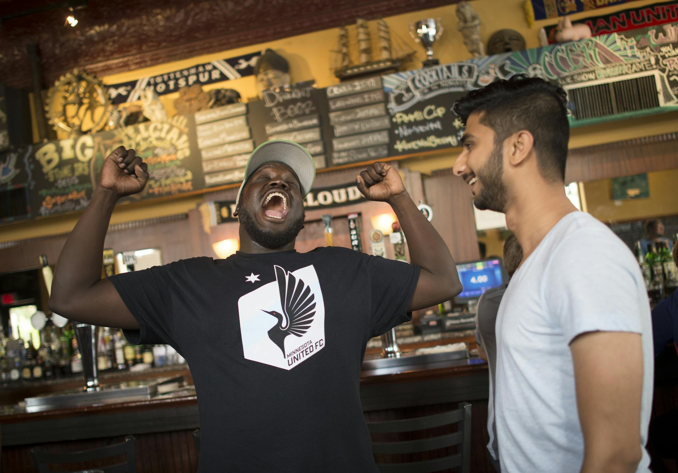 Abraham Opoti, left, of Minneapolis, joked with Dark Clouds organizer Nachiket Karnik at Nomad World Pub before Saturday night's Minnesota United FC game against the Ottawa Fury FC. ] Aaron Lavinsky • aaron.lavinsky@startribune.com Feature on Dark Clouds fan group of Minnesota United soccer. They are a non-stop cheering bunch of soccer nuts who follow the team and support it with non-stop orchestrated cheering at games.