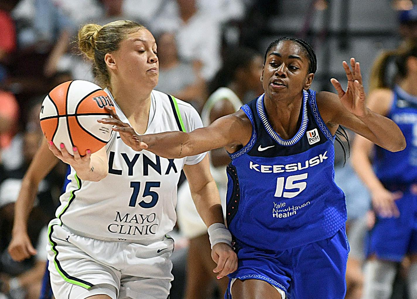 Connecticut Sun's Tiffany Hayes (15) attempts to steal the ball from Minnesota Lynx's Rachel Banham (15) during a WNBA basketball game, Sunday, Sept. 17, 2023 at Mohegan Sun Arena in Uncasville, Conn. (Sarah Gordon/The Day via AP)