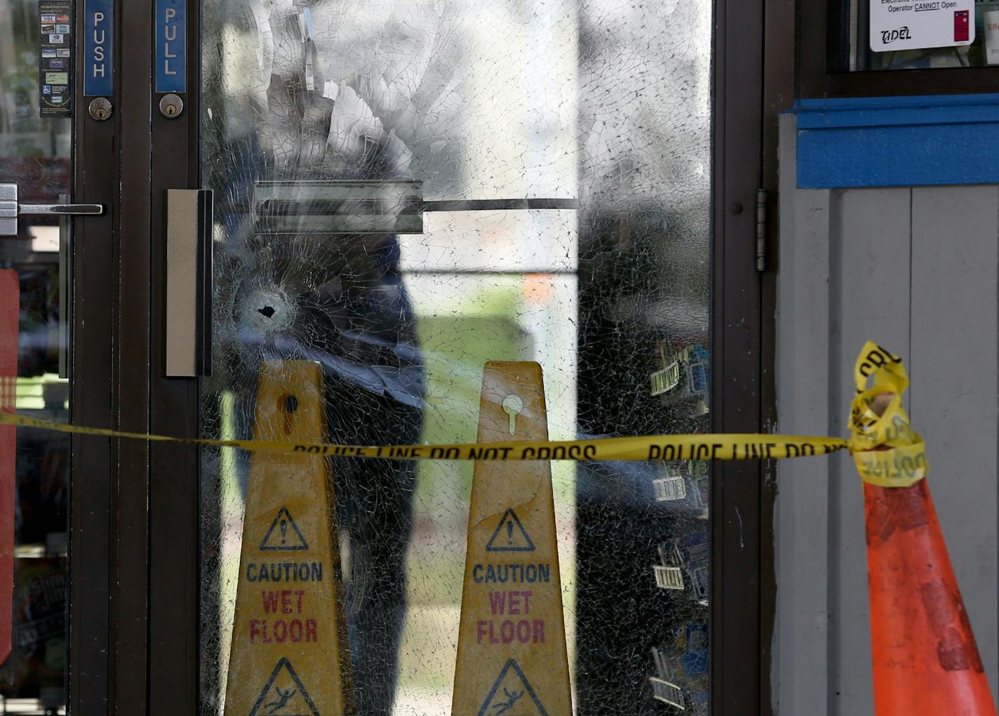 What appeared to be a bullet hole in the glass door at the Moto Mart on Hiawatha Ave and 33rd Street. ] (KYNDELL HARKNESS/STAR TRIBUNE) kyndell.harkness@startribune.com At Moto Mart in Minneapolis Min., Tuesday, September 23, 2014. Three people were in the hospital after they were shot early Tuesday at a south Minneapolis gas station