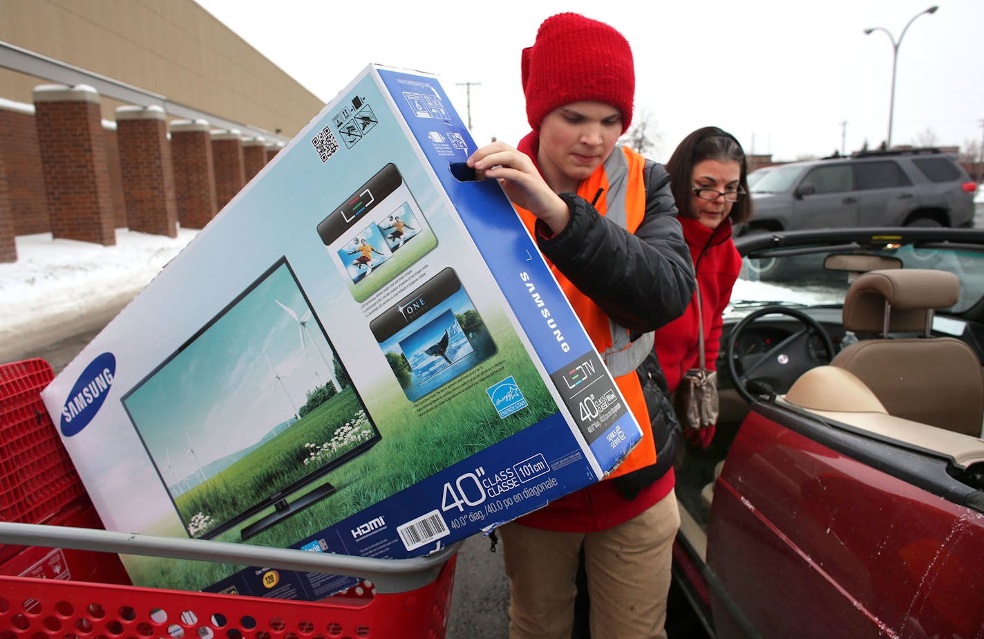 Target employee Wyatt Buchanan helped put a new television in the car of Denise Dian, of Roseville, at Target in Roseville on Saturday, Dec. 21, 2013. Dian decided to do more shopping with the 10% discount. "I always buy on sale. I would have bought that item maybe next week maybe four weeks from now, two months from now instead i bought it today, " she said.