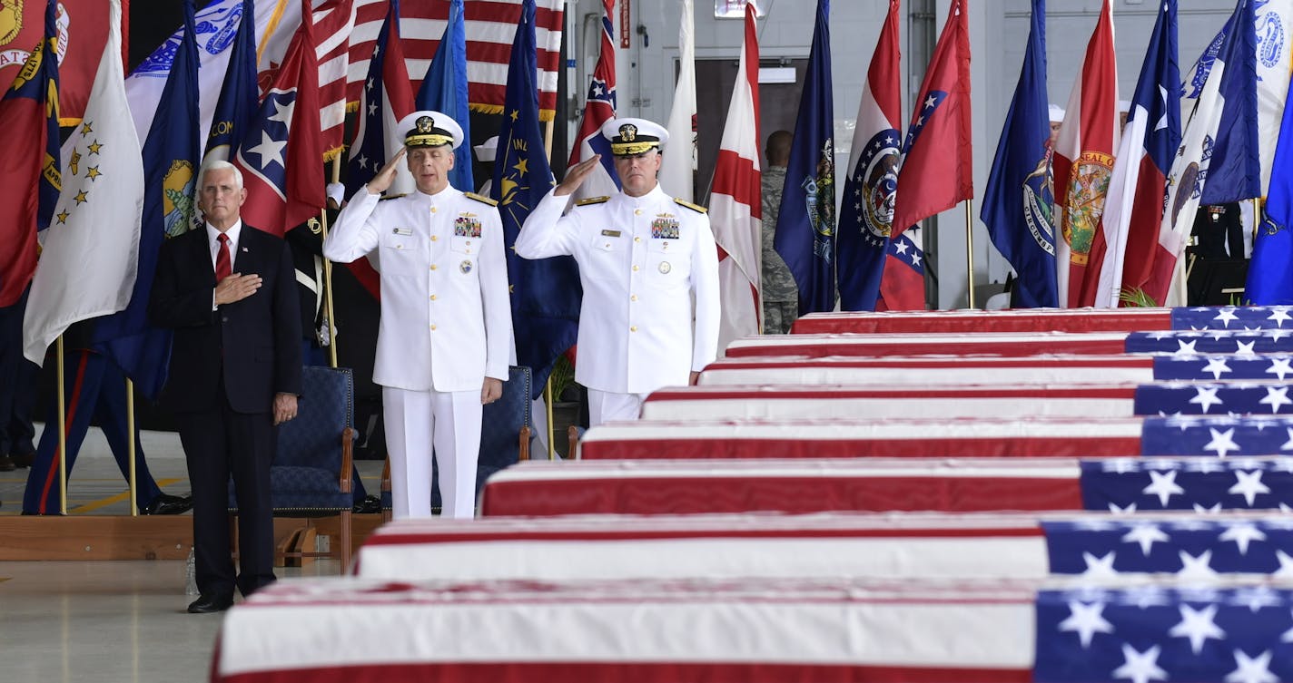 Vice President Mike Pence, left, Commander of U.S. Indo-Pacific Command Adm. Phil Davidson, center, and Rear Adm. Jon Kreitz, deputy director of the POW/MIA Accounting Agency, attend at a ceremony marking the arrival of the remains believed to be of American service members who fell in the Korean War at Joint Base Pearl Harbor-Hickam, Hawaii, Wednesday, Aug. 1, 2018. North Korea handed over the remains last week. (AP Photo/Susan Walsh)