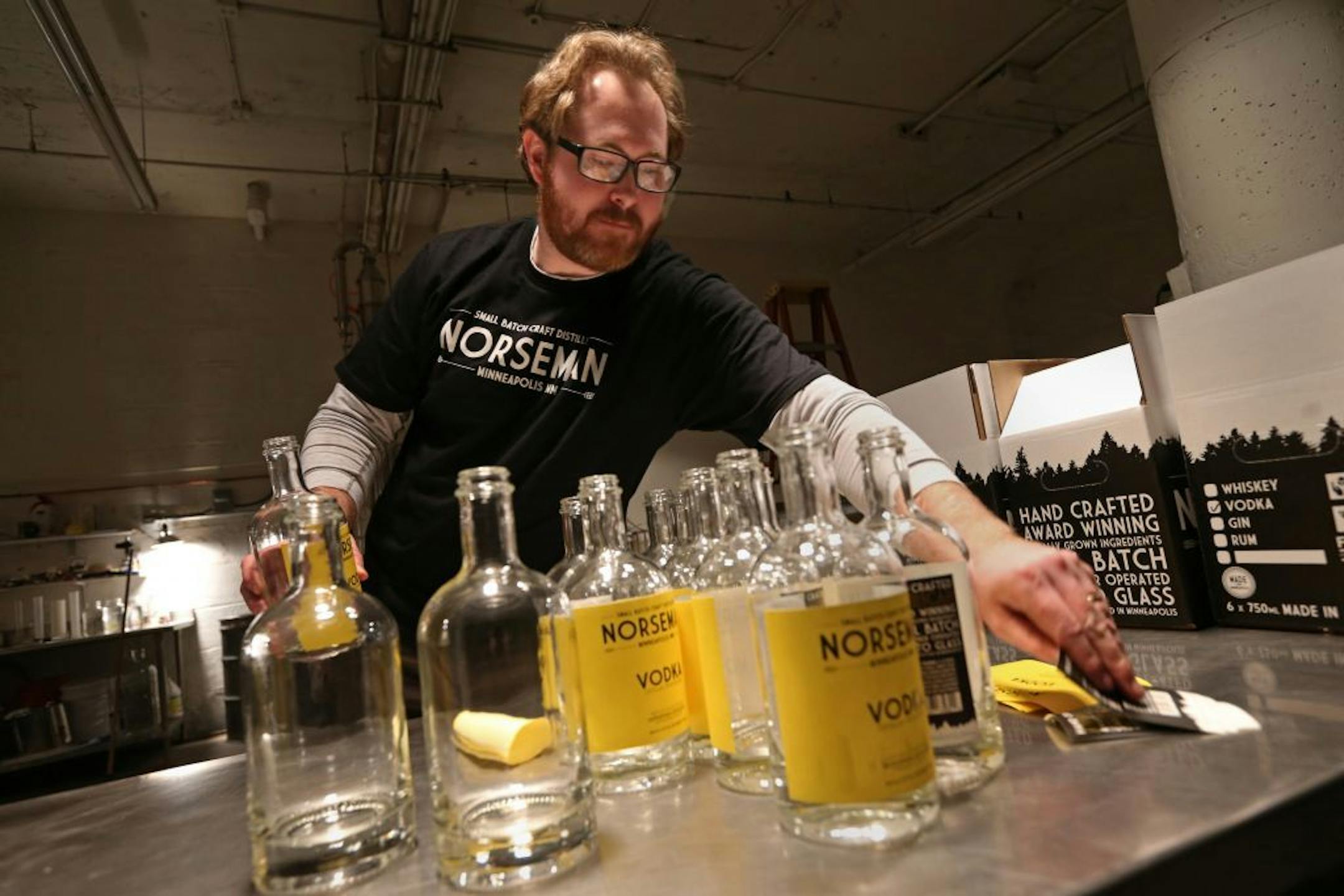 Scott Ervin applied labels to the bottles before filling with Norseman Vodka on 1/10/14. The year starts off with a high-proof bang, as micro-distillers open in the metro. One of the first to actually have product in stores and bars is the small Norseman Distillery in NE Mpls., run by Scott Ervin.