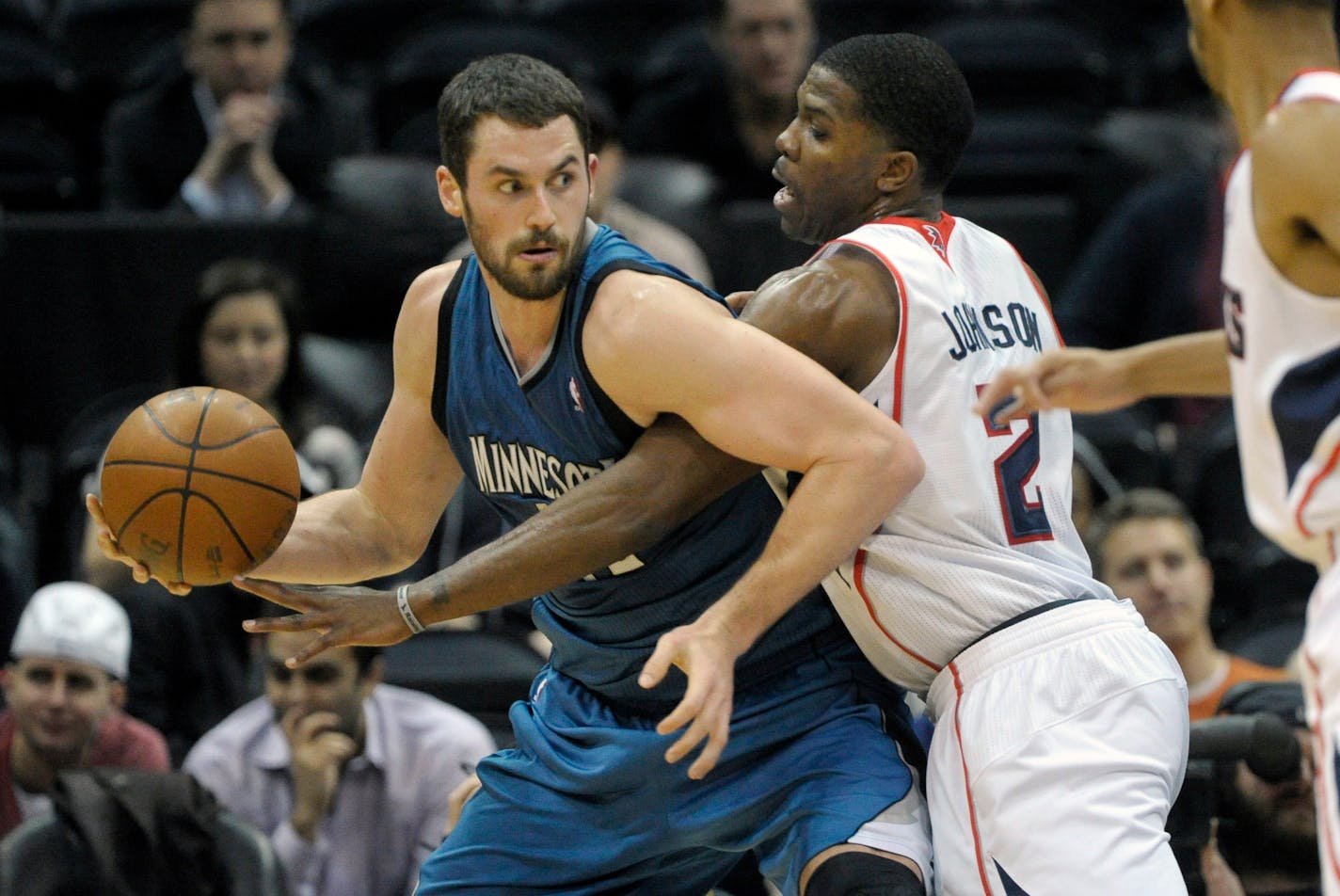 Minnesota Timberwolves power Kevin Love (42) tries to keep the ball from the defense of Atlanta Hawks guard Joe Johnson (2) during the first half of an NBA , basketball game, Saturday, Jan. 14, 2012, in Atlanta. (AP Photo/John Amis)