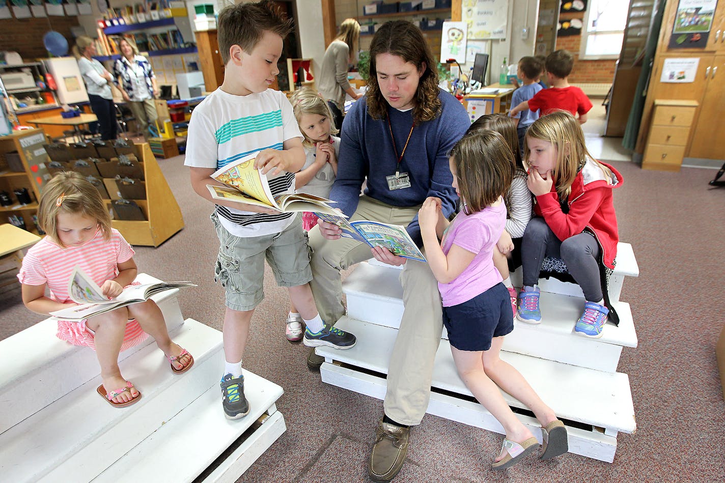 Gophers offensive tackle Jonah Pirsig is surrounded by kindergarten students as he read a story at Highlands Elementary, Tuesday, May 5, 2015 in Edina, MN. It is part of his education curriculum. ] (ELIZABETH FLORES/STAR TRIBUNE) ELIZABETH FLORES &#x2022; eflores@startribune.com