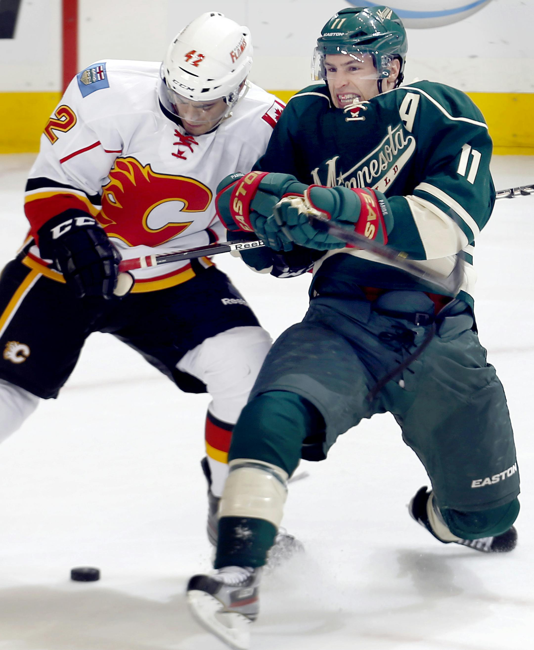 Mark Cundari (42) and Zach Parise (11) fought for the puck in the third period. ] CARLOS GONZALEZ cgonzalez@startribune.com April 21, 2013, St. Paul, Minn., Xcel Energy Center, NHL, Minnesota Wild vs. Calgary Flames