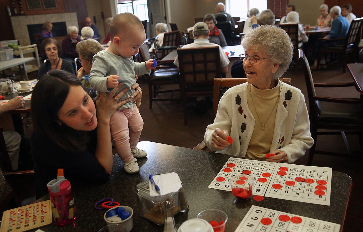 Elsie Gustavson, 94, played bingo at her assisted living facility in Maplewood, while baby Elsie Williams and her mother, Amy, kept her company.