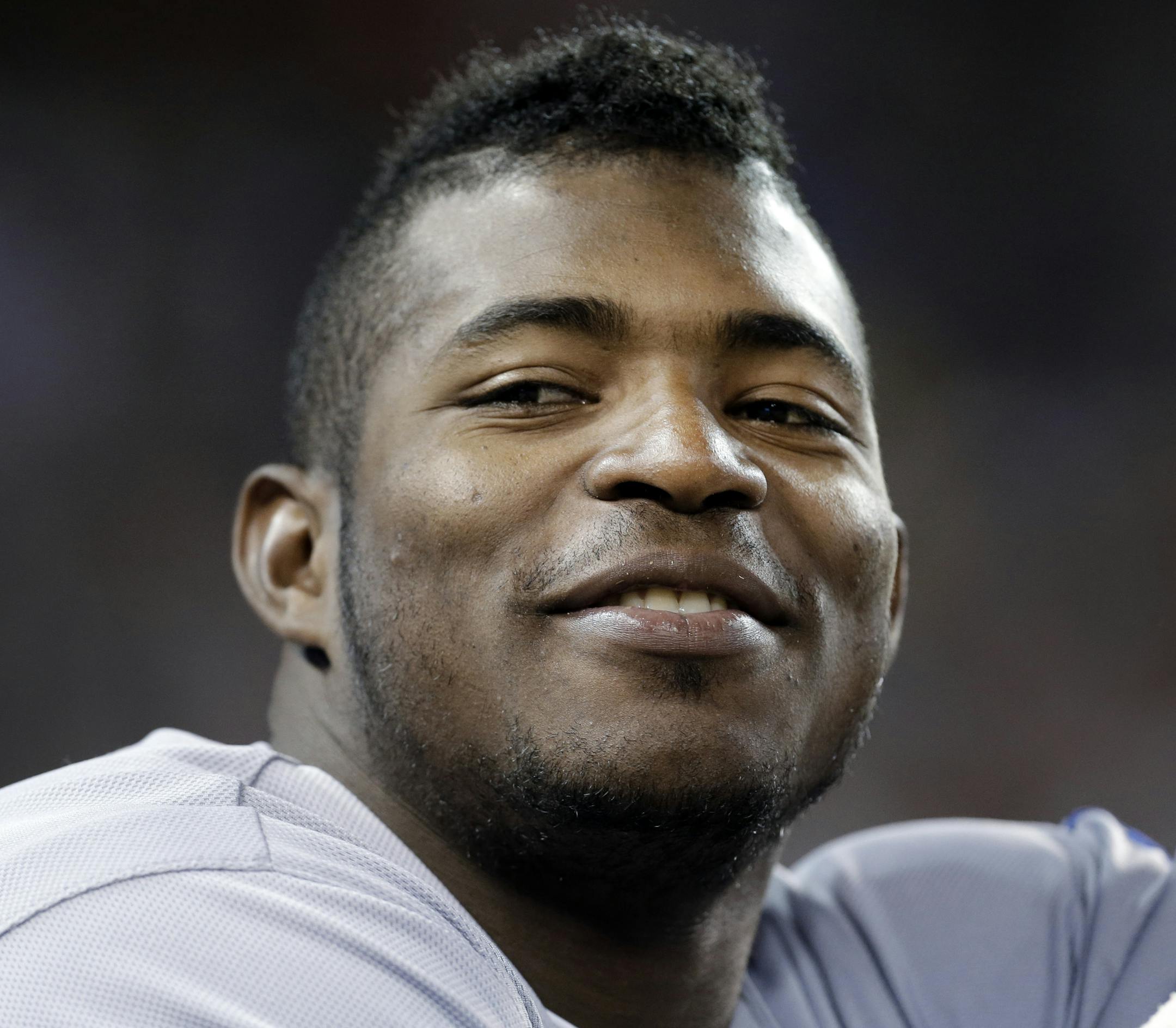 Los Angeles Dodgers right fielder Yasiel Puig smiles in the dugout against the Detroit Tigers in the sixth inning of a baseball game in Detroit, Tuesday, July 8, 2014. (AP Photo/Paul Sancya) ORG XMIT: MIPS10
