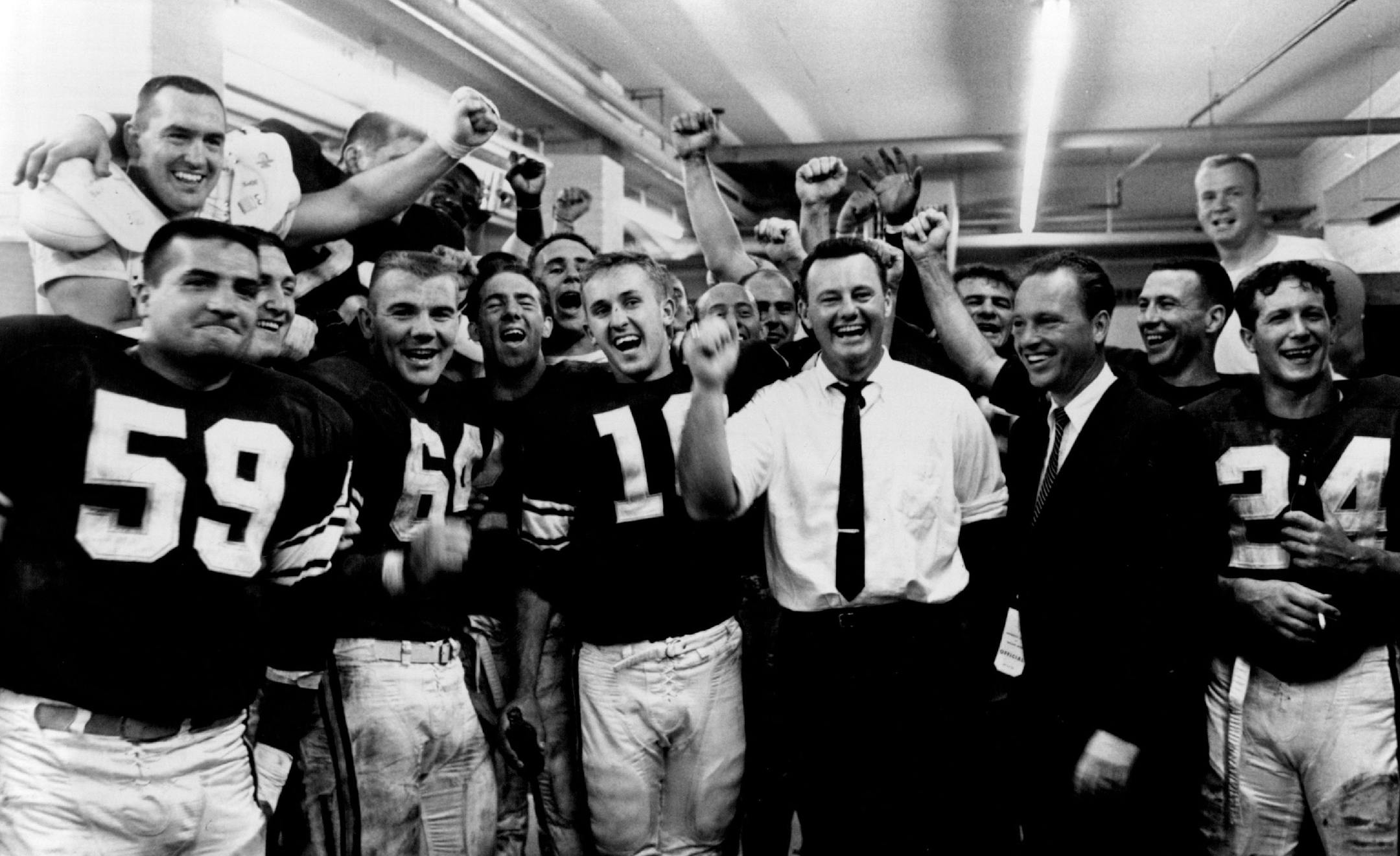 Coach Norm Van Brocklin, in white shirt, leads a Viking victory yell as general manager Bert Rose joins in.