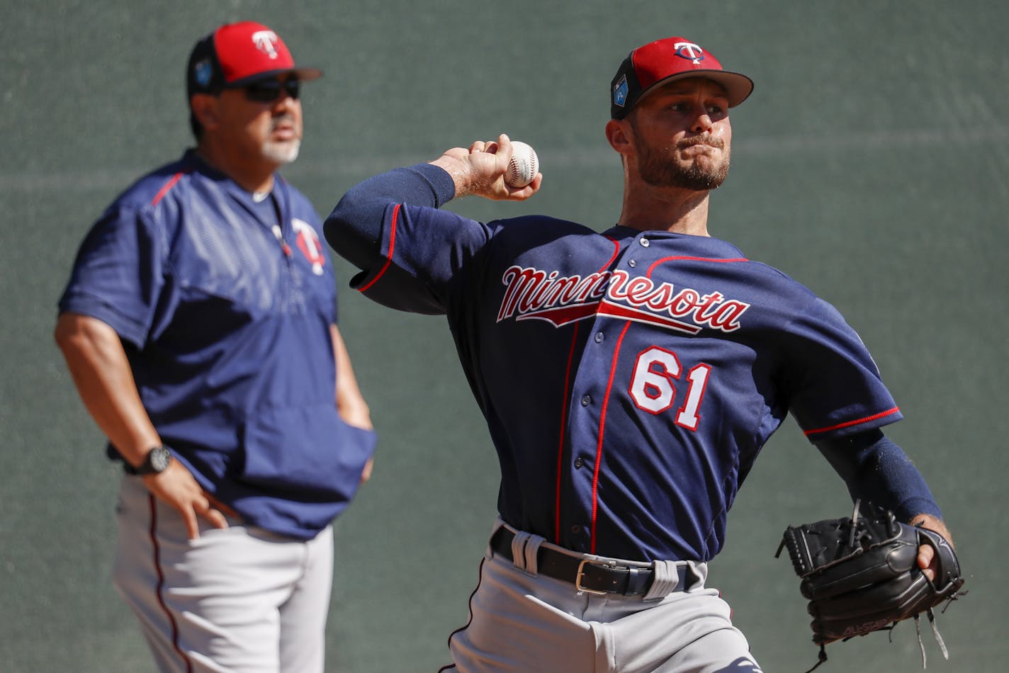 Minnesota Twins relief pitcher Tyler Kinley (61) practices as coaching staff looks on in the bullpen during baseball spring training, Saturday, Feb. 17, 2018, in Fort Myers, Fla. (AP Photo/John Minchillo)