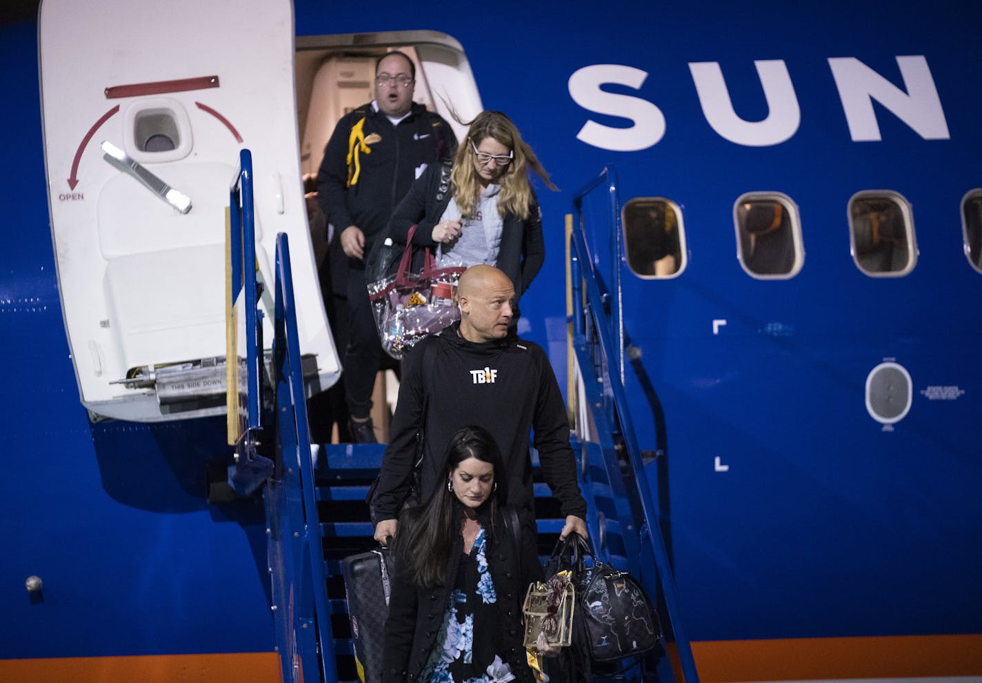 Preceded by his wife, Heather, Gophers head coach P.J. Fleck descended the stairs after arriving at Sun Country's hangar with his team Sunday night. ] JEFF WHEELER &#x2022; Jeff.Wheeler@startribune.com The University of Minnesota football team arrived back in Minneapolis Sunday night, January 1, 2020 fresh from their Outback Bowl win over Auburn. They arrived on a charter flight at Sun Country's hanger at Minneapolis - St. Paul International Airport.