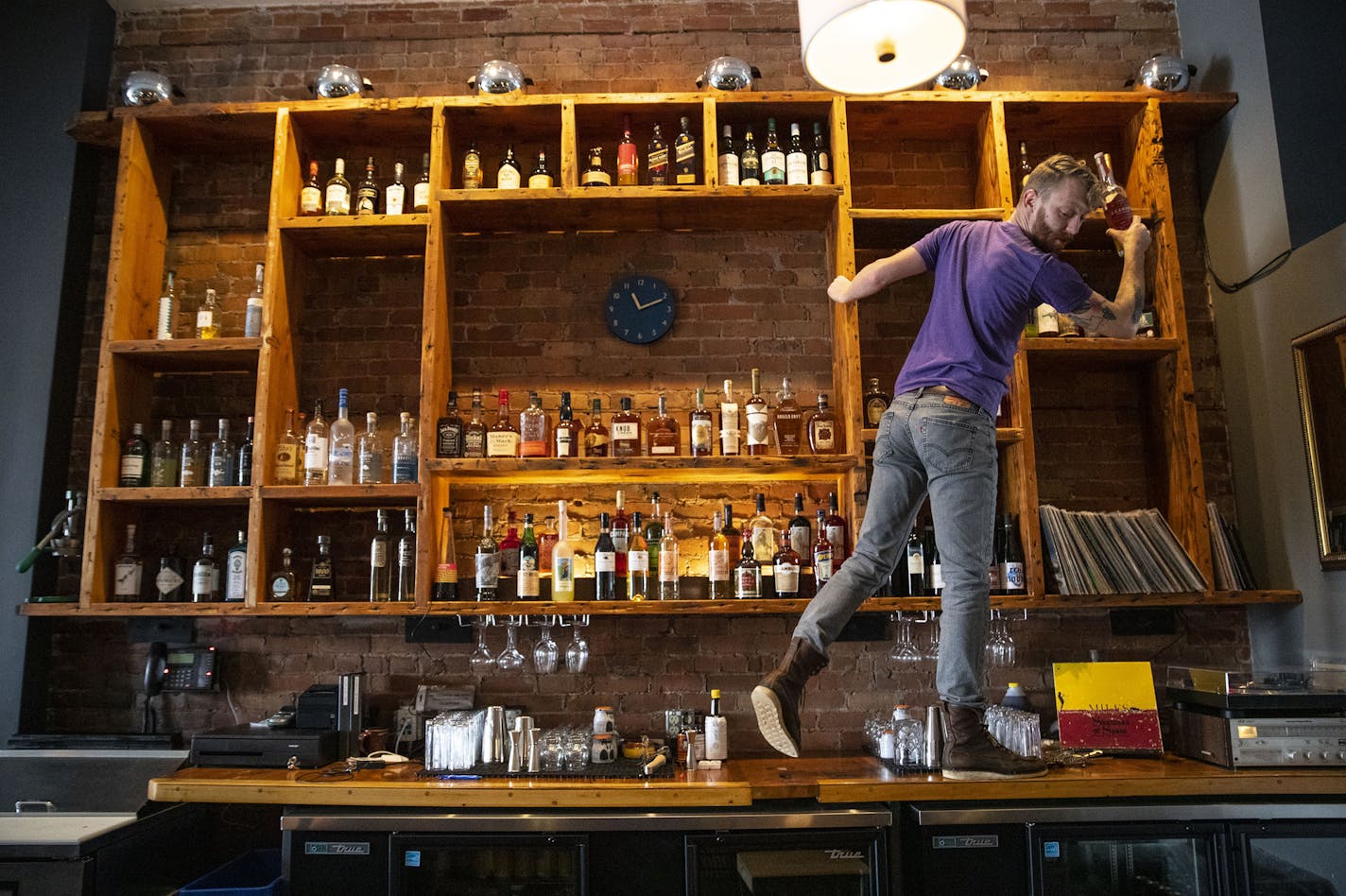 Noble Pour general manager Tyler Schwanke reached up to grab a spirit high behind the bar on Thursday December 12, 2019. ]
ALEX KORMANN &#x2022; alex.kormann@startribune.com Noble Pour is a cocktail lounge opening in Duluth, MN on Sunday. It is the newest venture by Tom Hanson, the co-owner of OMC Smokehouse and Duluth Grill.