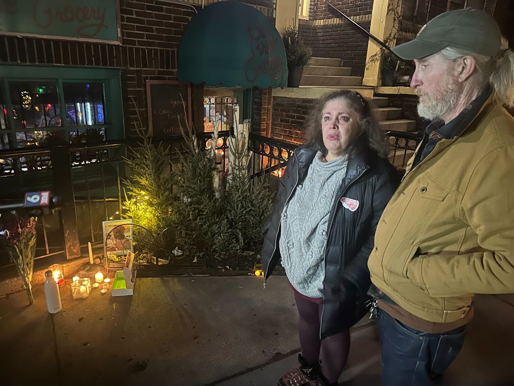 Gladys Torres and Randy Zandt stood outside a memorial for Robert Skafte at Oak Grove Grocery on Friday night.