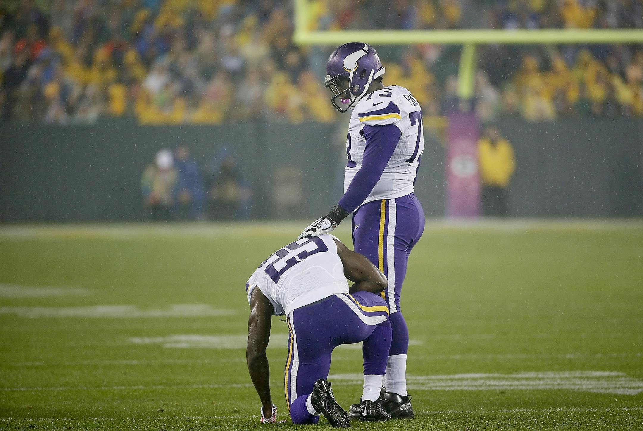 Minnesota Vikings cornerback Xavier Rhodes (29) was slow to get up as he is helped by defensive tackle Sharrif Floyd (73) in the first quarter as the Minnesota Vikings took on the Green Bay Packers at Lambeau Field, Thursday, October 2, 2014 in Green Bay, Wis.