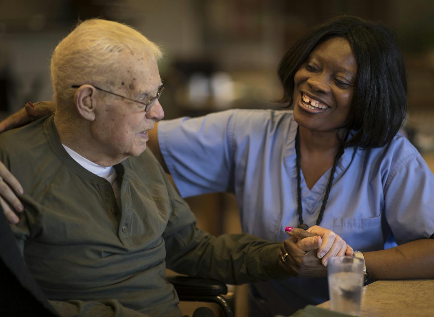 "We all live in fear. We don't know what will happen after the 31st," said nursing assistant and DED recipient Christina Wilson, above, with patient John Russell at St. Therese of New Hope.