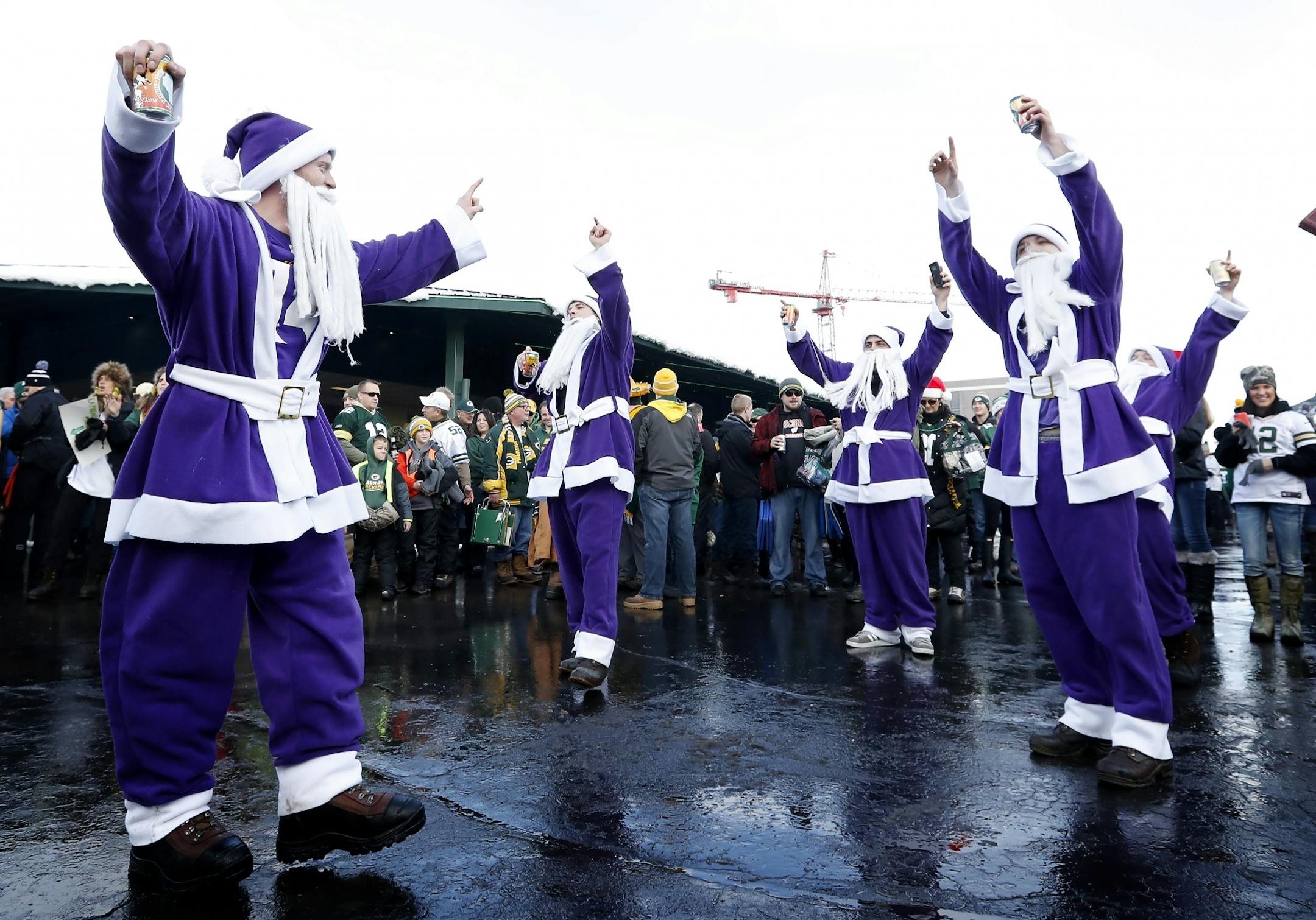 Jack Halverson, 24, Philip Fanjul, 25, David Bajari, 25, Mitch Benson, 25, Kevin Neraasen, 25 all of Minneapolis all dressed as Purple Santa Claus as they danced across from Lambeau Field in Green Bay, WI before the Minnesota Vikings vs. Green Bay Packers game.