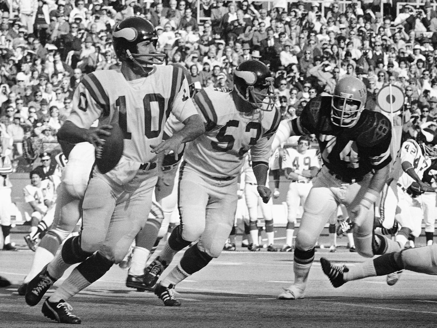 Minnesota Vikings quarterback Fran Tarkenton (10) has trouble getting rid of the ball in first-half action against the Bengals, Dec. 2, 1973 in Cincinnati, Ohio. Vikings Mick Tingeloff (53) provides same protection for Tarkenton against Cincinnati?s Mike Reid (74). (AP Photo) ORG XMIT: APHS254996