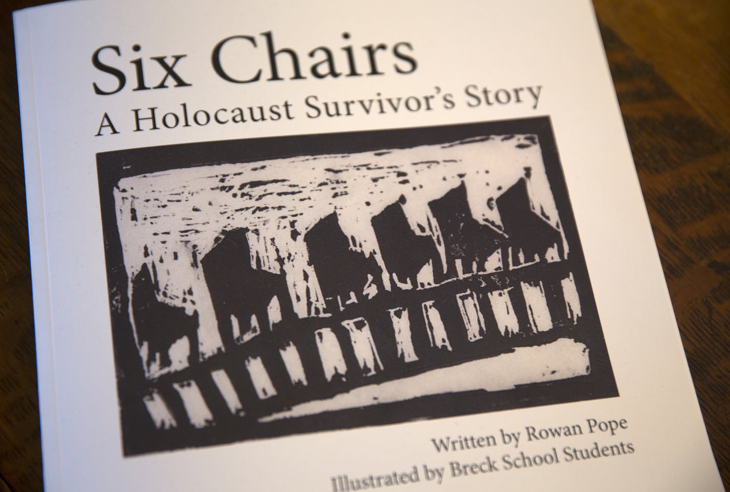 Local artist Rowan Pope holds a copy of the book "Six Chairs: A Holocaust Survivor's Story" inside his home studio in St. Paul. ] LEILA NAVIDI leila.navidi@startribune.com / BACKGROUND INFORMATION: Friday, January 30, 2015. Rowan Pope, in collaboration with Breck Middle School, wrote the book "Six Chairs: A Holocaust Survivor's Story" which was illustrated by Breck Middle School students, about local Holocaust survivor Joe Grosnacht.