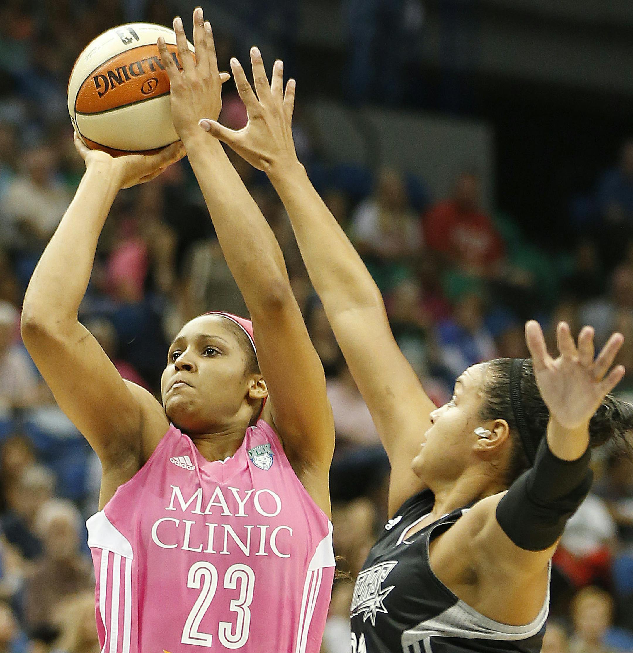 Minnesota Lynx forward Maya Moore (23) goes up for a basket against San Antonio Stars guard Kayla McBride during the first half of a WNBA basketball game, Friday, July 25, 2014, in Minneapolis. (AP Photo/Stacy Bengs)