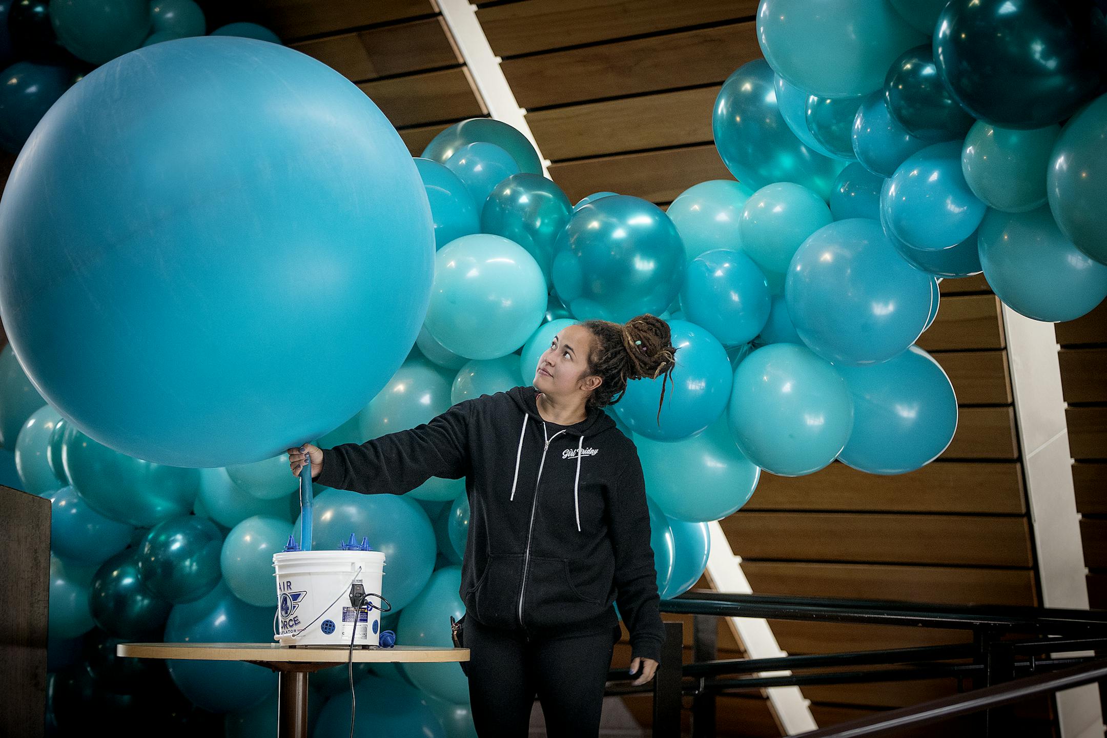 Girl Friday's Jasmine Hamsa blew up a 4-foot balloon to be placed on a decorative installation at the U of M's McNamara Alumni Center's large Memorial Hall event space.
