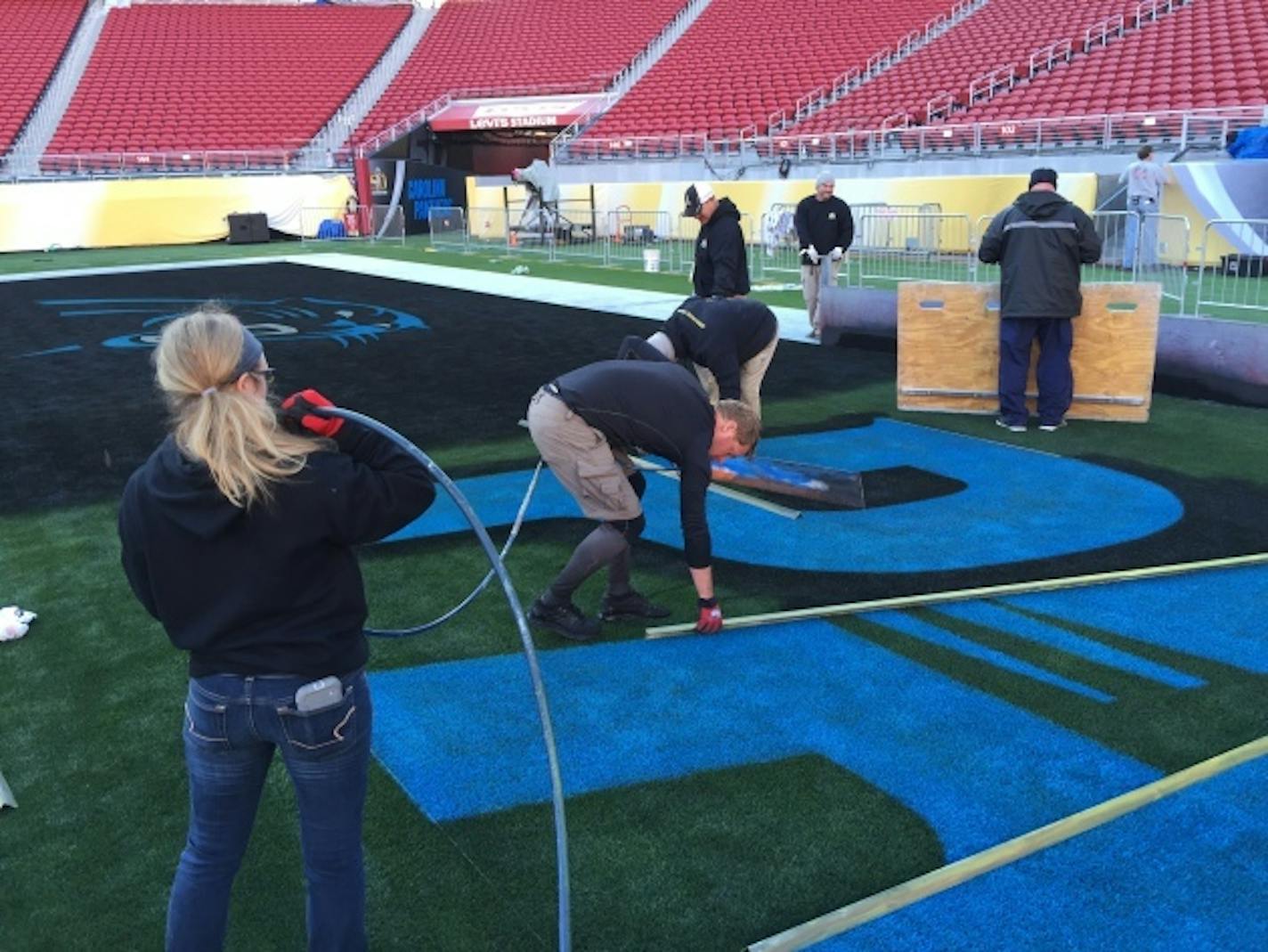 Georgeanna Heitshusen helps paint the Carolina endzone for Super Bowl 50.         Photo courtesy of The Toro Co.