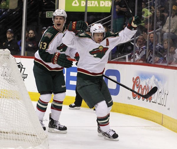 Minnesota Wild left wing Zach Parise, front, celebrates his goal with right wing Charlie Coyle