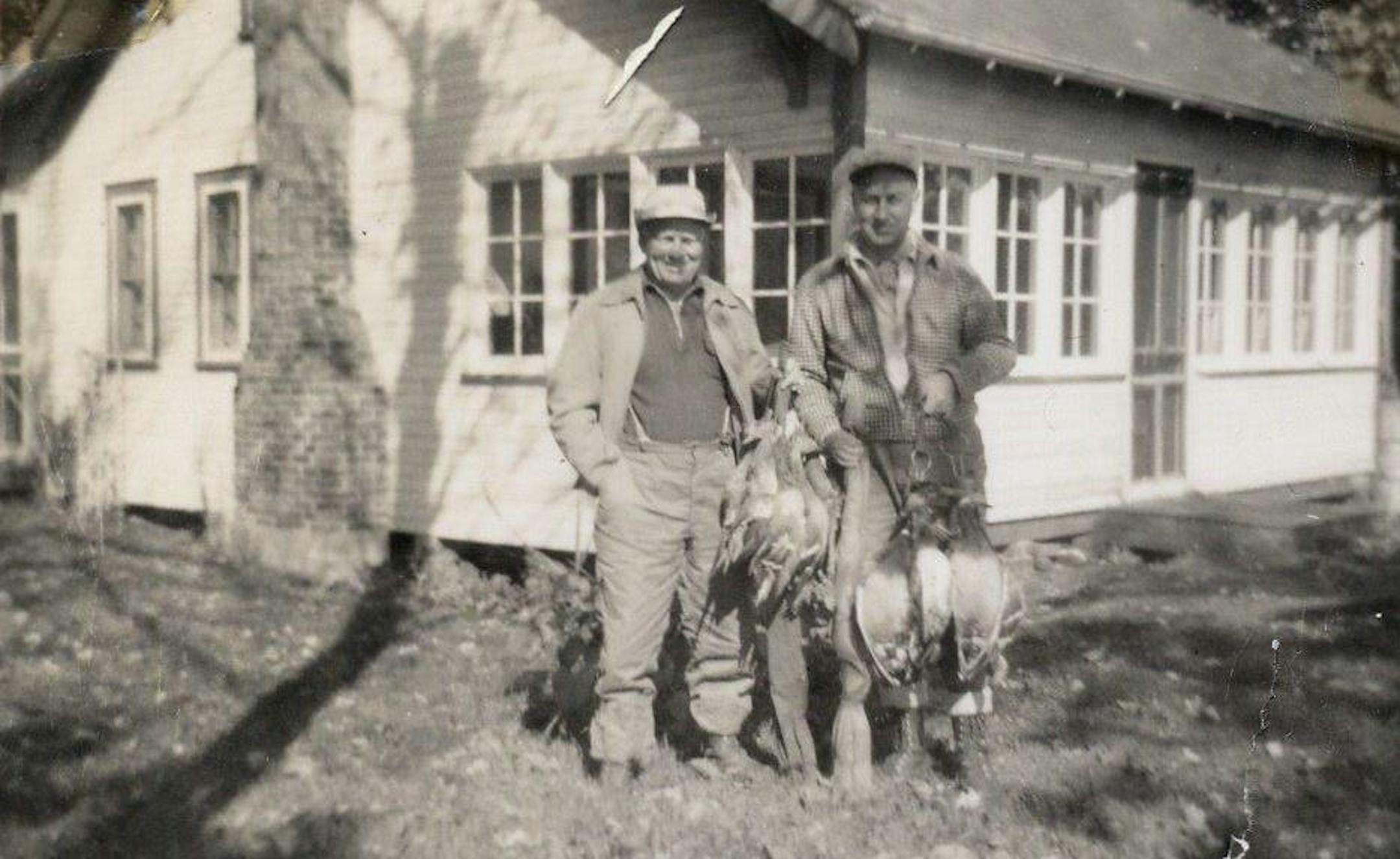 Lohmann's father-in-law, Henry Lohmann (at left), in 1950, standing before his newly purchased cabin with friend George Lau.