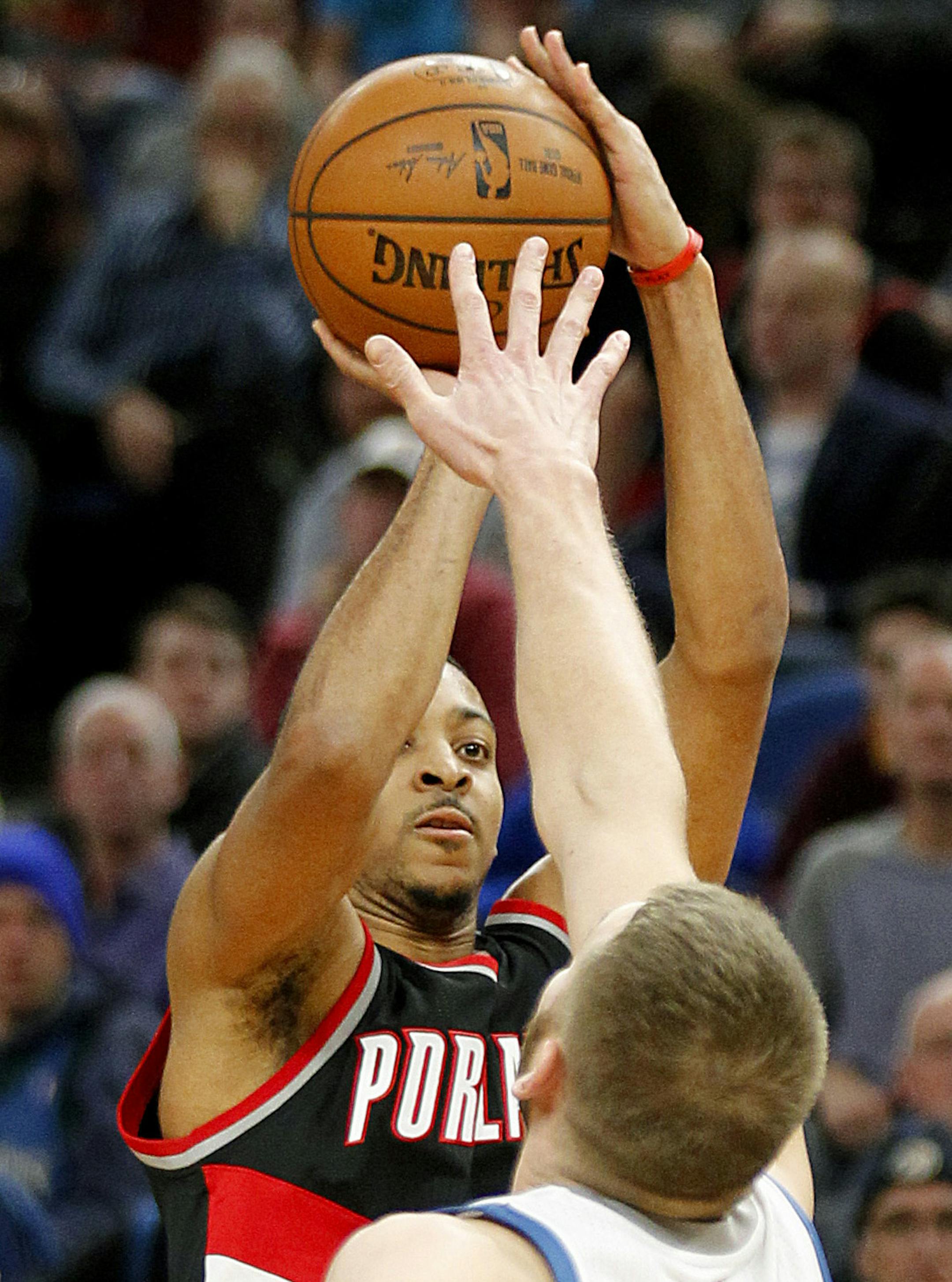 Portland Trail Blazers guard C.J. McCollum shoots in front of Minnesota Timberwolves center Cole Aldrich during the fourth quarter of an NBA basketball in Minneapolis, Sunday, Jan. 1, 2017. The Trail Blazers won 95-89. (AP Photo/Andy Clayton-King)