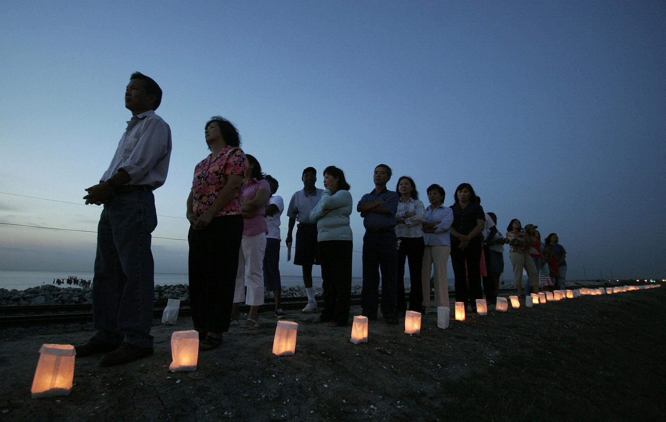 Residents of eastern New Orleans hold a candlelight vigil with 1600 candles to commemorate those who lost their lives after the devastation of Hurricane Katrina nearly one year ago in New Orleans on Monday, Aug. 28, 2006. The bags with the candles are on the Lake Ponchartrain Levee in eastern New Orleans. The event included the playing of "Amazing Grace," and "Taps."(AP Photo/Alex Brandon) ORG XMIT: LAAB136