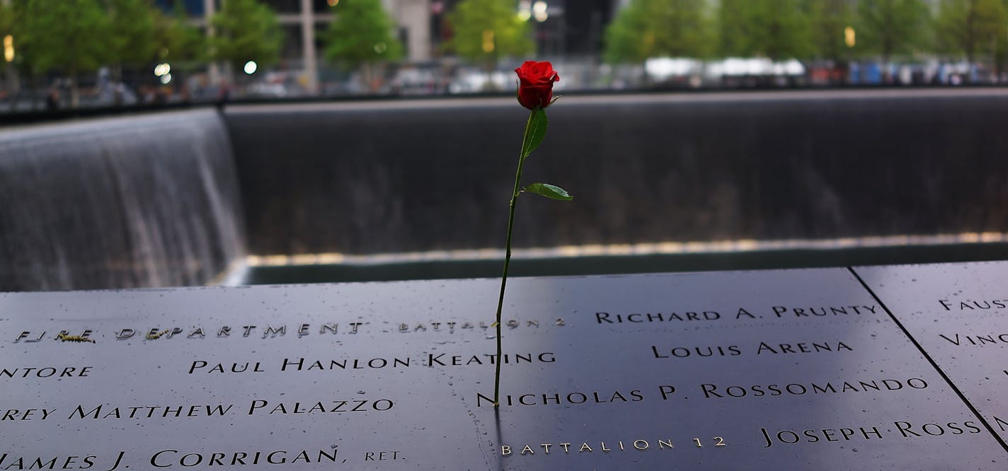 A rose is placed on a name engraved along the South reflecting pool at the Ground Zero memorial site during the dedication ceremony of the National September 11 Memorial Museum in New York on Thursday, May 15, 2014. (AP Photo/Spencer Platt, Pool) ORG XMIT: NYDK142