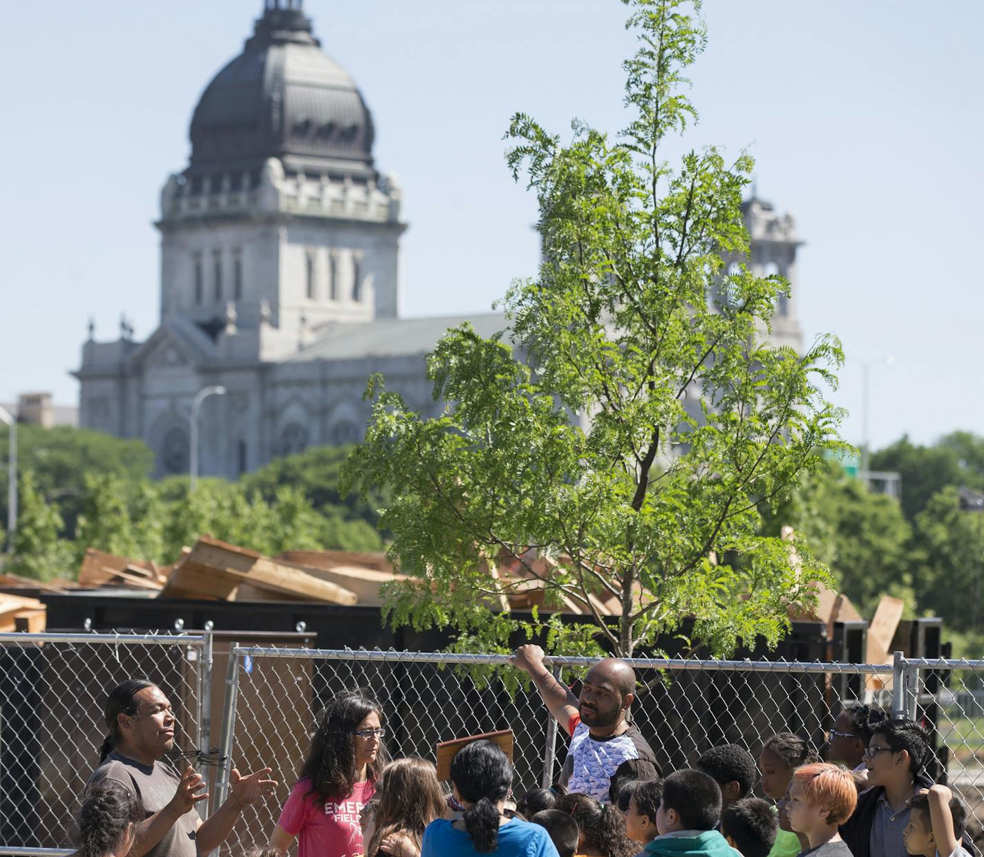 Sam Wounded Knee, left, talked to fourth-grade students from Emerson Spanish Immersion school about the sculpture.