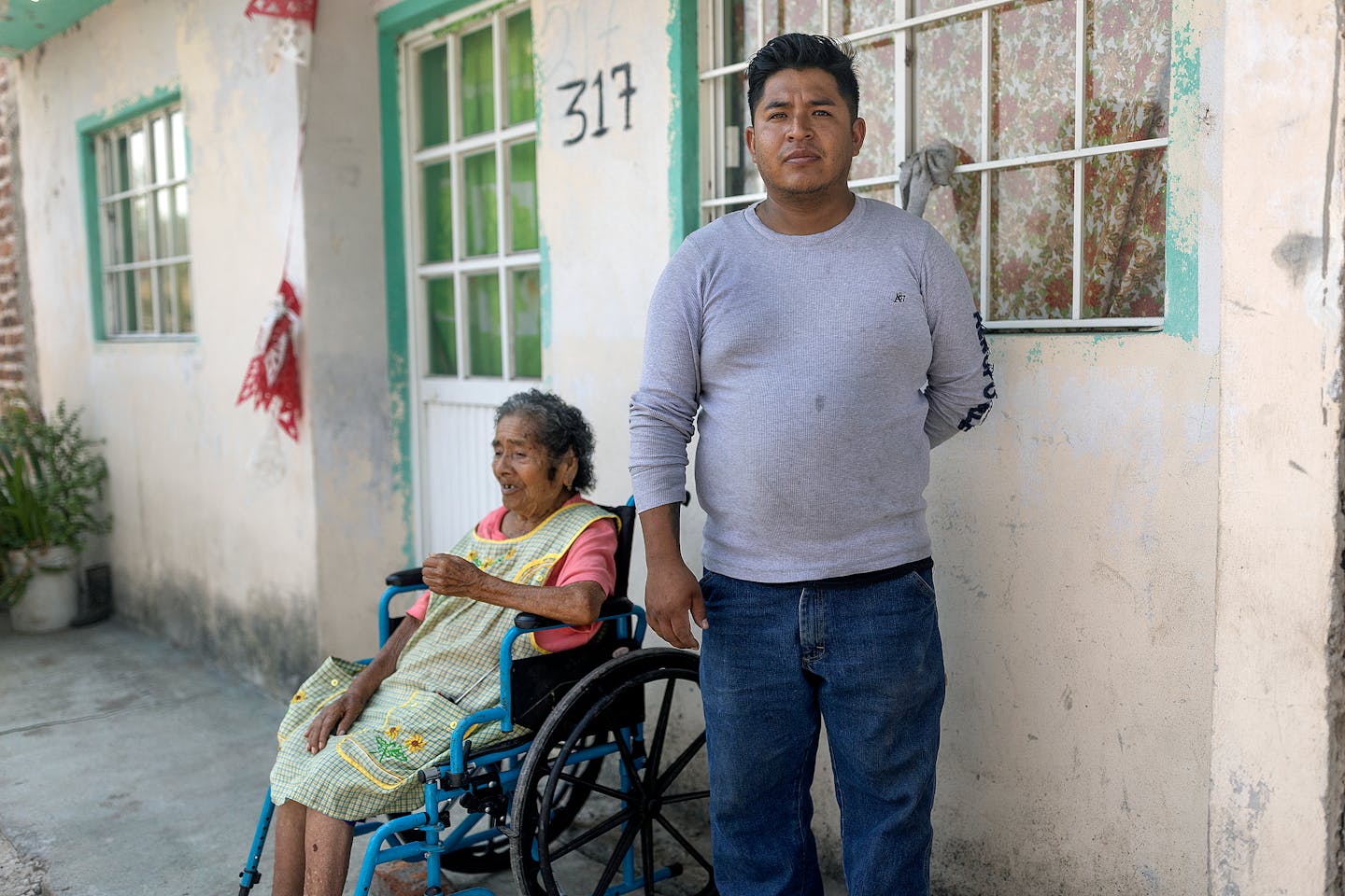 José Guadalupe Martinez García cares for his grandmother in Salvatierra, Guanajuato, Mexico. García, who once worked at the HyLife pork processing 