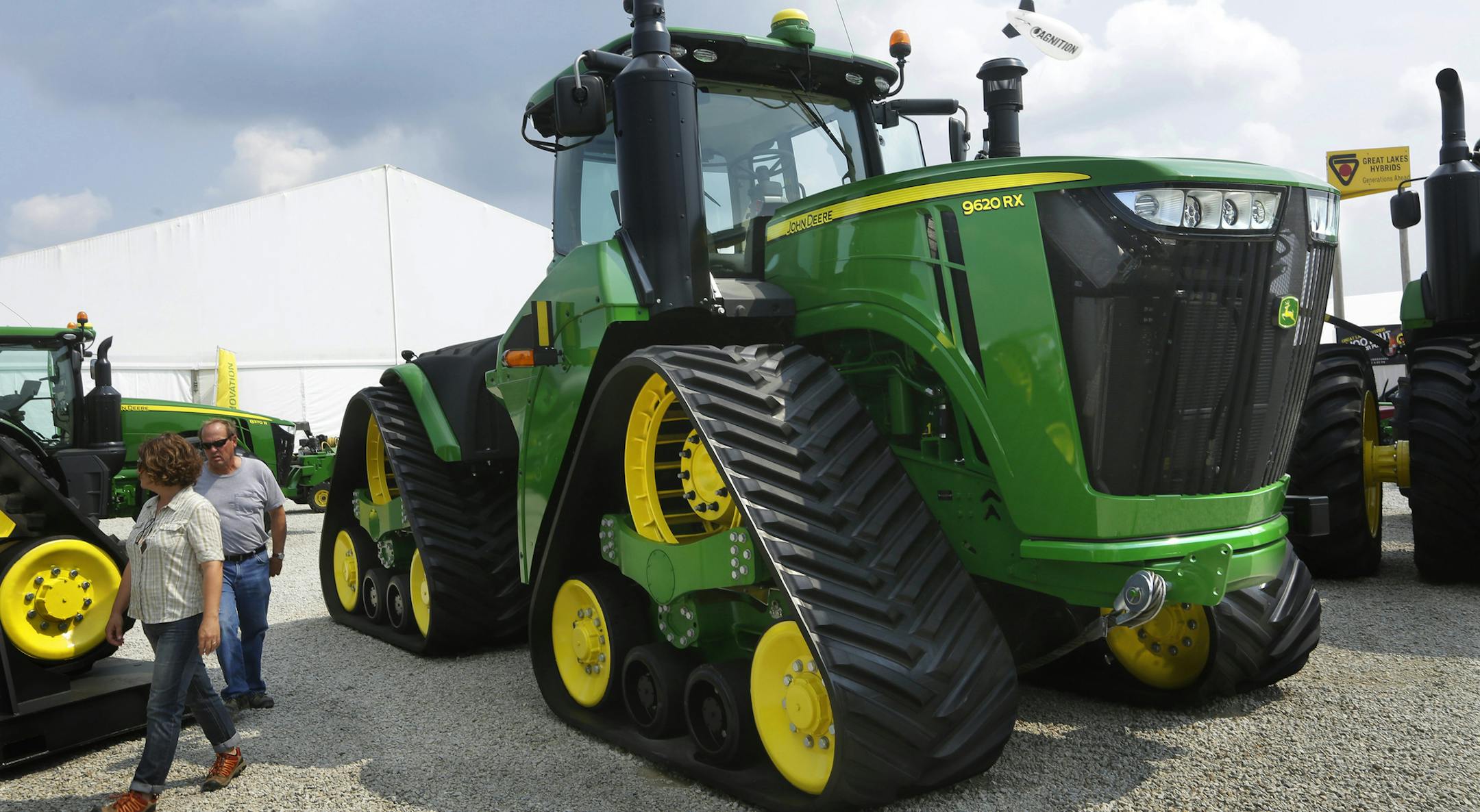 FILE - In this Monday, Aug. 31, 2015, file photo, Douglas and Monika Johnson from Perry, Iowa, look at John Deere equipment on display at the Farm Progress Show in Decatur, Ill. Deere & Co. report financial results Friday, Aug. 19, 2016. (AP Photo/Seth Perlman, File)