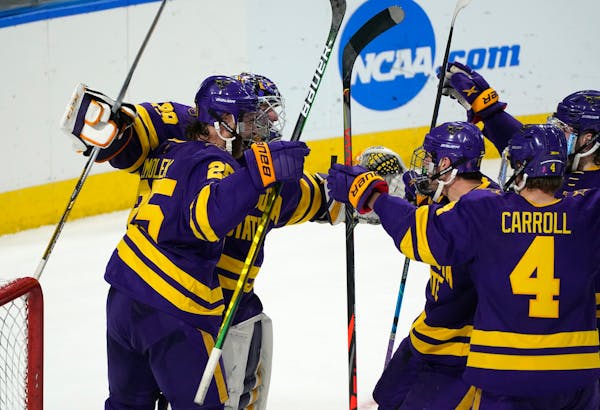 Minnesota State players surround goaltender Dryden McKay, back left, as time runs out in the third period of an NCAA College Hockey Regional Final aga