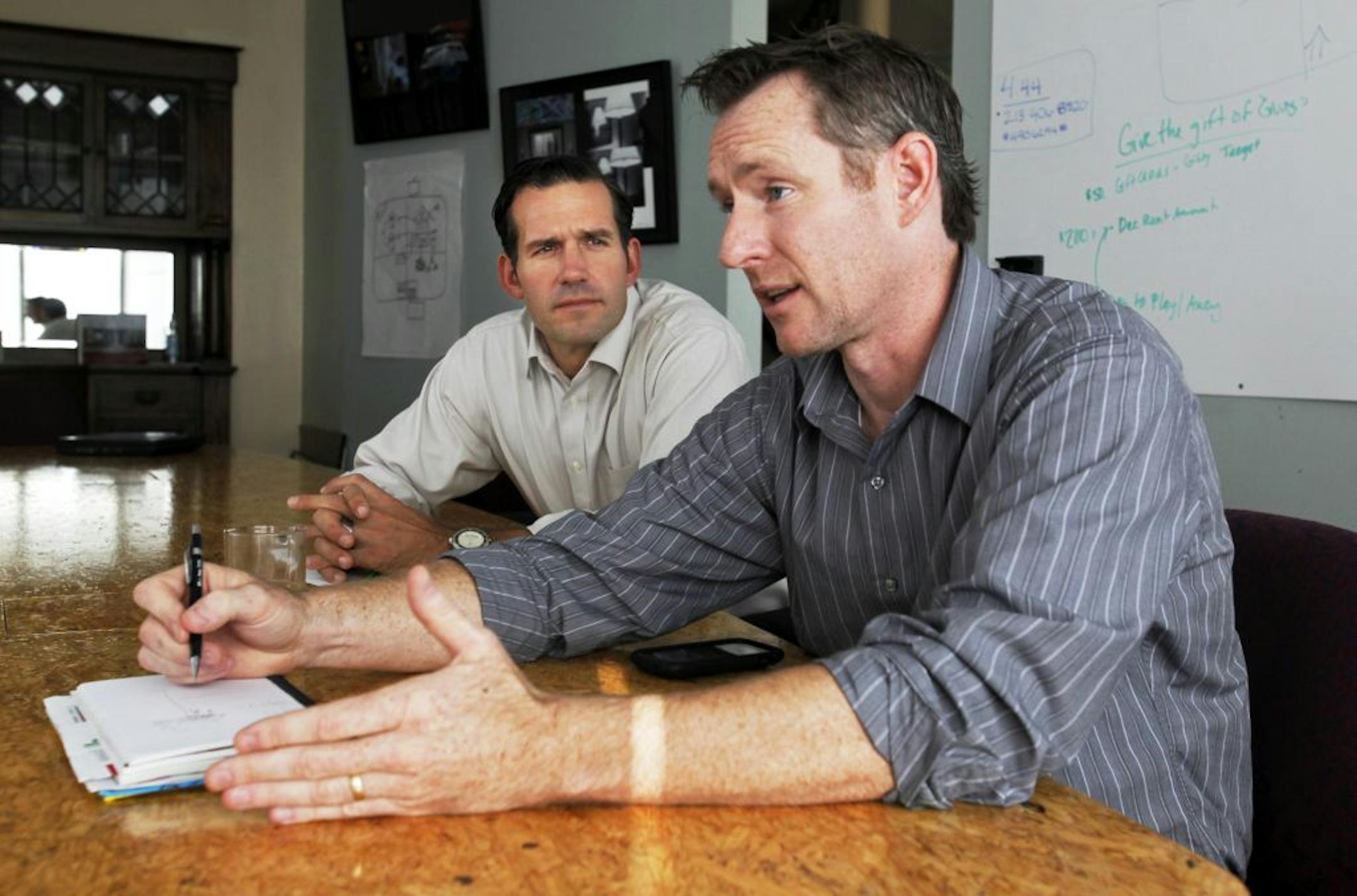 Chad Schwitters, president/executive director of Urban Homeworks, front, and Jeff Washburne, executive directer of the City of Lakes Community Land Trust, have joined forces to form a special contract-for-deed program called Project Reclaim that is being run by the two non-profits. The men were photographed discussing Project Reclaim at Urban Homeworks Thursday, Sept. 8, 2011, in Minneapolis, MN.
