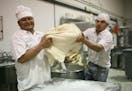 Amelio Sanchez, left, and Saul Andraca transferred dough from a mixer to a table Friday afternoon at the Saint Agnes Baking Co. in St. Paul.