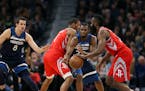 Timberwolves forward Andrew Wiggins (22) screened by Houston forward Trevor Ariza (1) as Rockets guard James Harden moved the ball upcourt in the firs