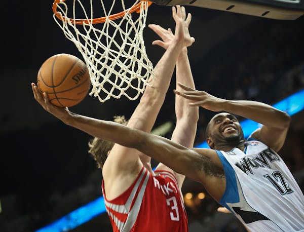 Wolves forward Luc Mbah a Moute snuck around the hoop for a basket against Houston's Omer Asik.
