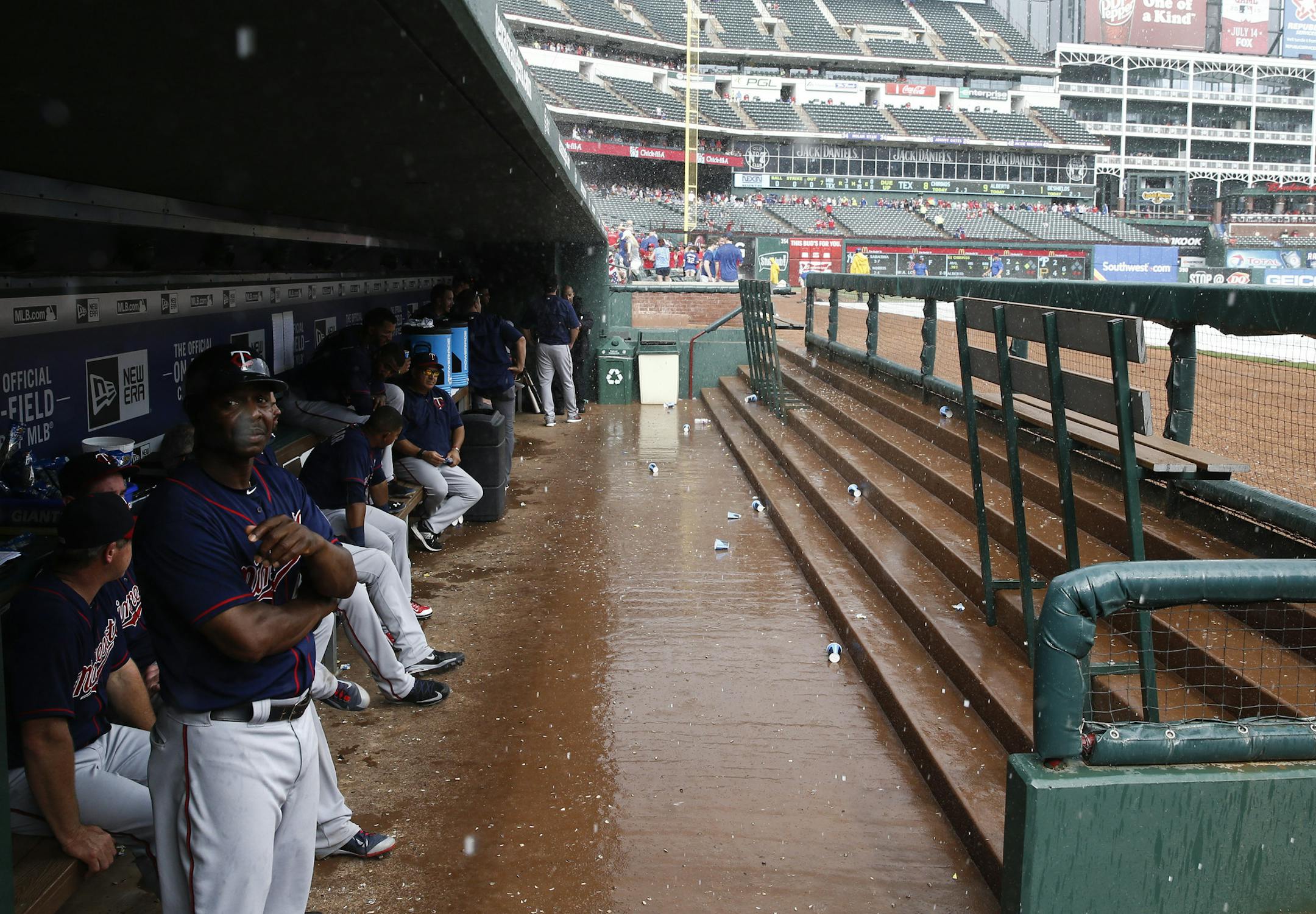 Minnesota Twins teammates wait in the dugout during a rain delay in the middle of the seventh inning of a baseball game against the Texas Rangers, Saturday, June 13, 2015, in Arlington, Texas. (AP Photo/Jim Cowsert)