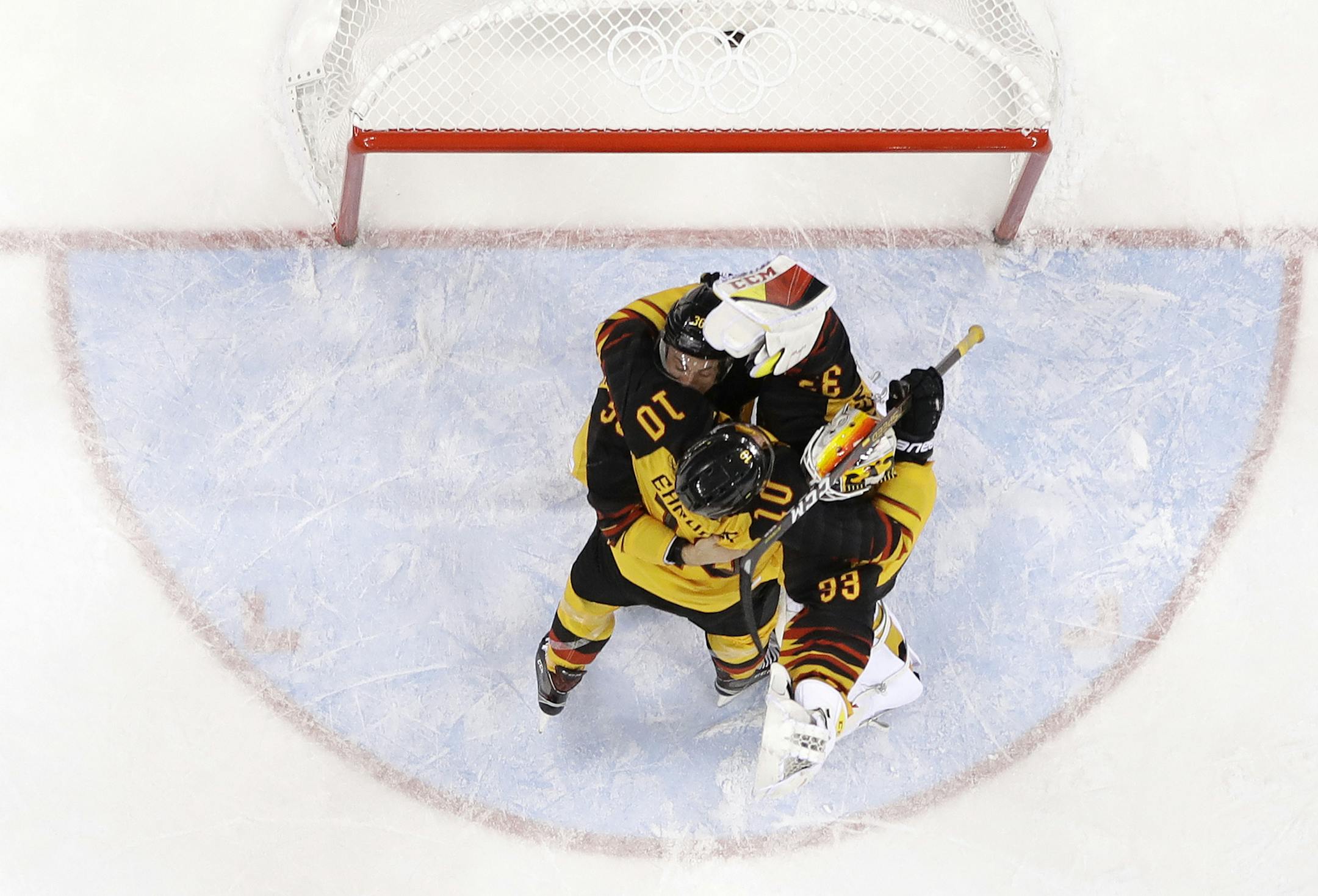 Christian Ehrhoff (10), Yannic Seidenberg (36), and goalie Den Birken Danny Aus (33), of Germany, celebrate after the semifinal round of the men's hockey game against Canada at the 2018 Winter Olympics in Gangneung, South Korea, Friday, Feb. 23, 2018. Germany won 4-3. (AP Photo/Julio Cortez)
