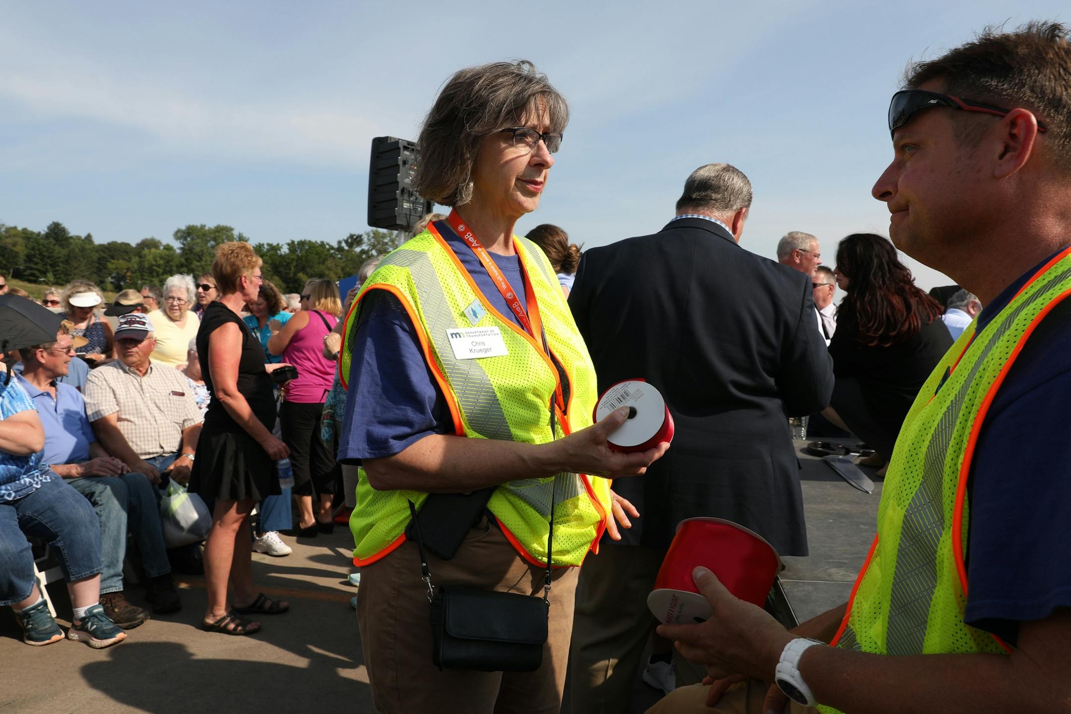 Chris Krueger, left, with MDot held the official ribbon for the ribbon-cutting ceremony as she and colleagues waited for it to begin.