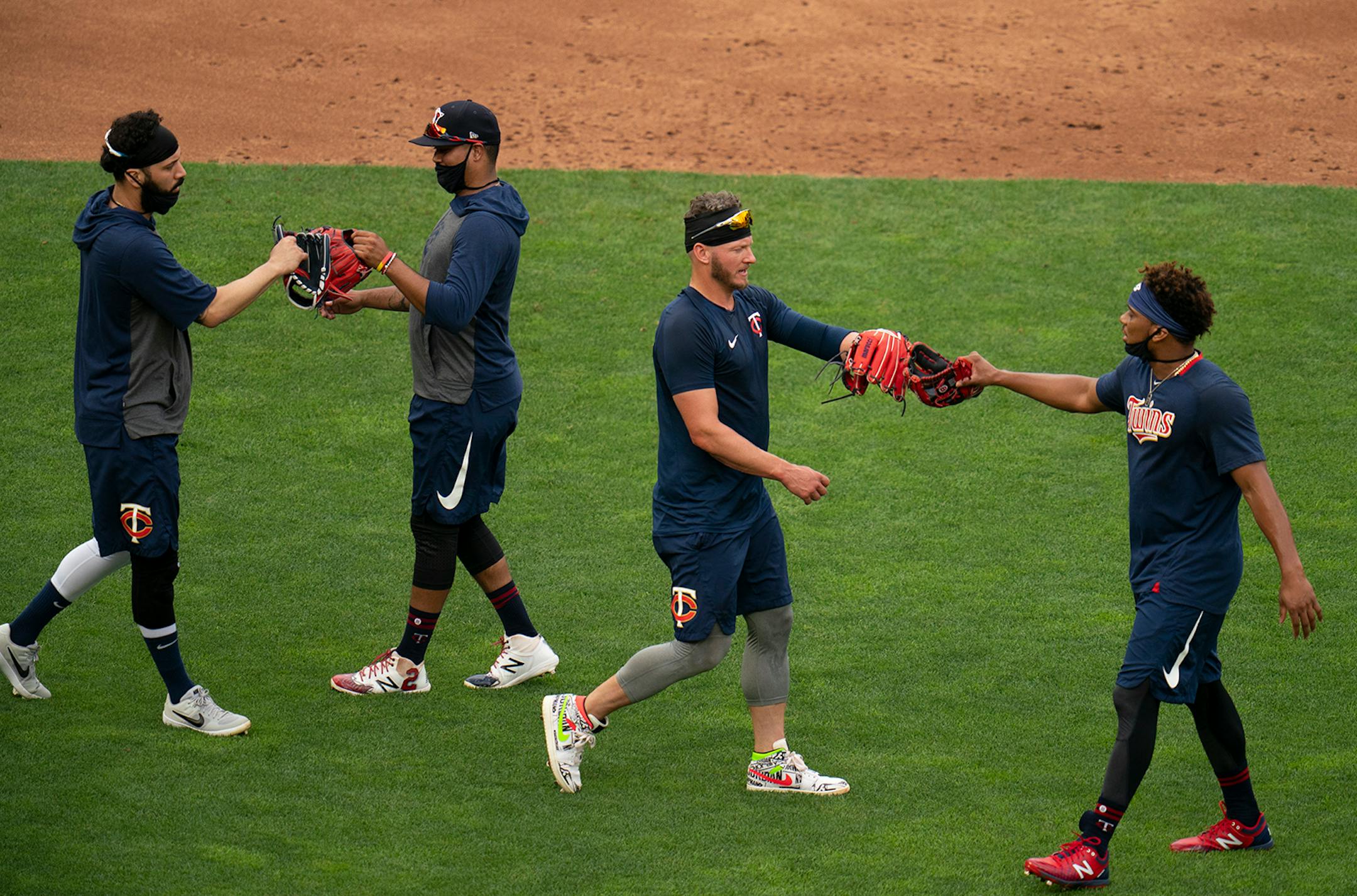 Twins players Marwin Gonzalez, left, and second baseman Luis Arraez touched gloves after infield drills ended, as did third baseman Josh Donaldson, and shortstop Jorge Polanco, right.