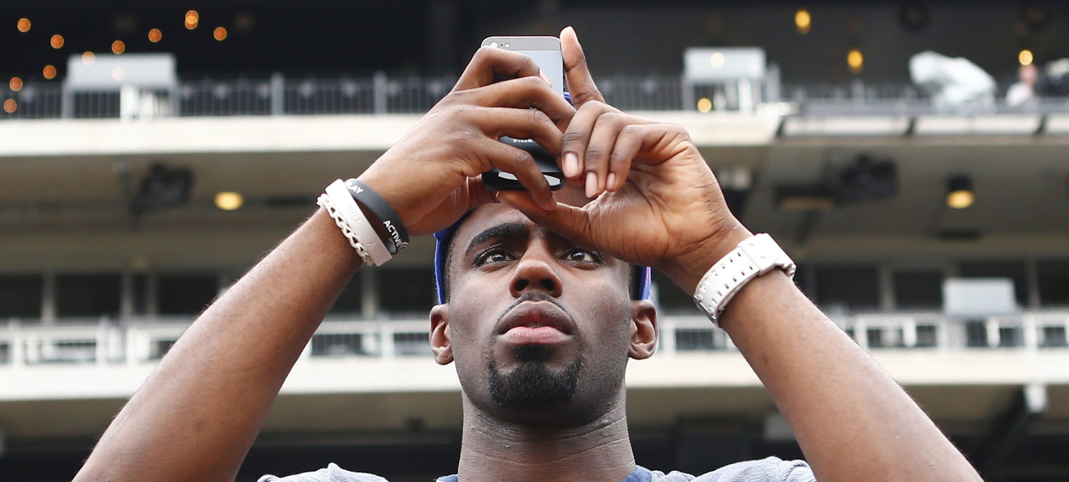 Tim Hardaway Jr. uses his cell phone to take photos of Citi Field before a baseball game between the New York Mets and the Washington Nationals at Citi Field in New York, Friday, June 28, 2013. The New York Knicks chose Hardaway in the first round of the NBA basketball draft. (AP Photo/Paul J. Bereswill) ORG XMIT: MIN2013071720200599