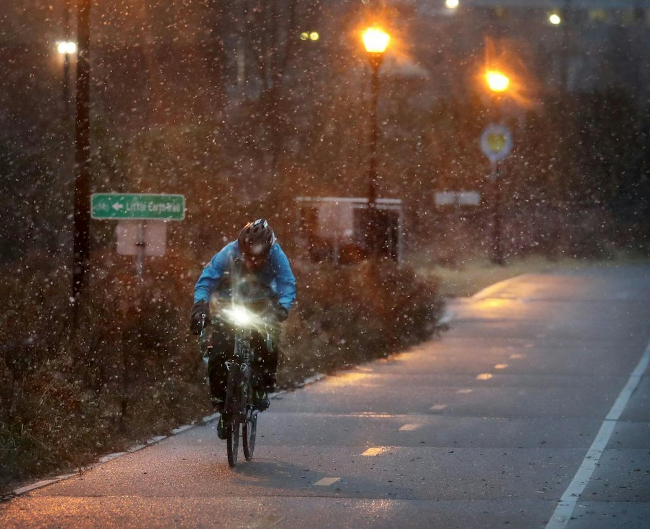 A bike commuter made his way towards the Martin Olav Sabo Bridge, above Hiawatha Avenue in the morning snow Thursday, Nov. 21, 2019, in Minneapolis. The National Weather Service has issued a winter storm watch for Tuesday night and Wednesday morning for the Twin Cities, as well as southern Minnesota and west central Wisconsin.
