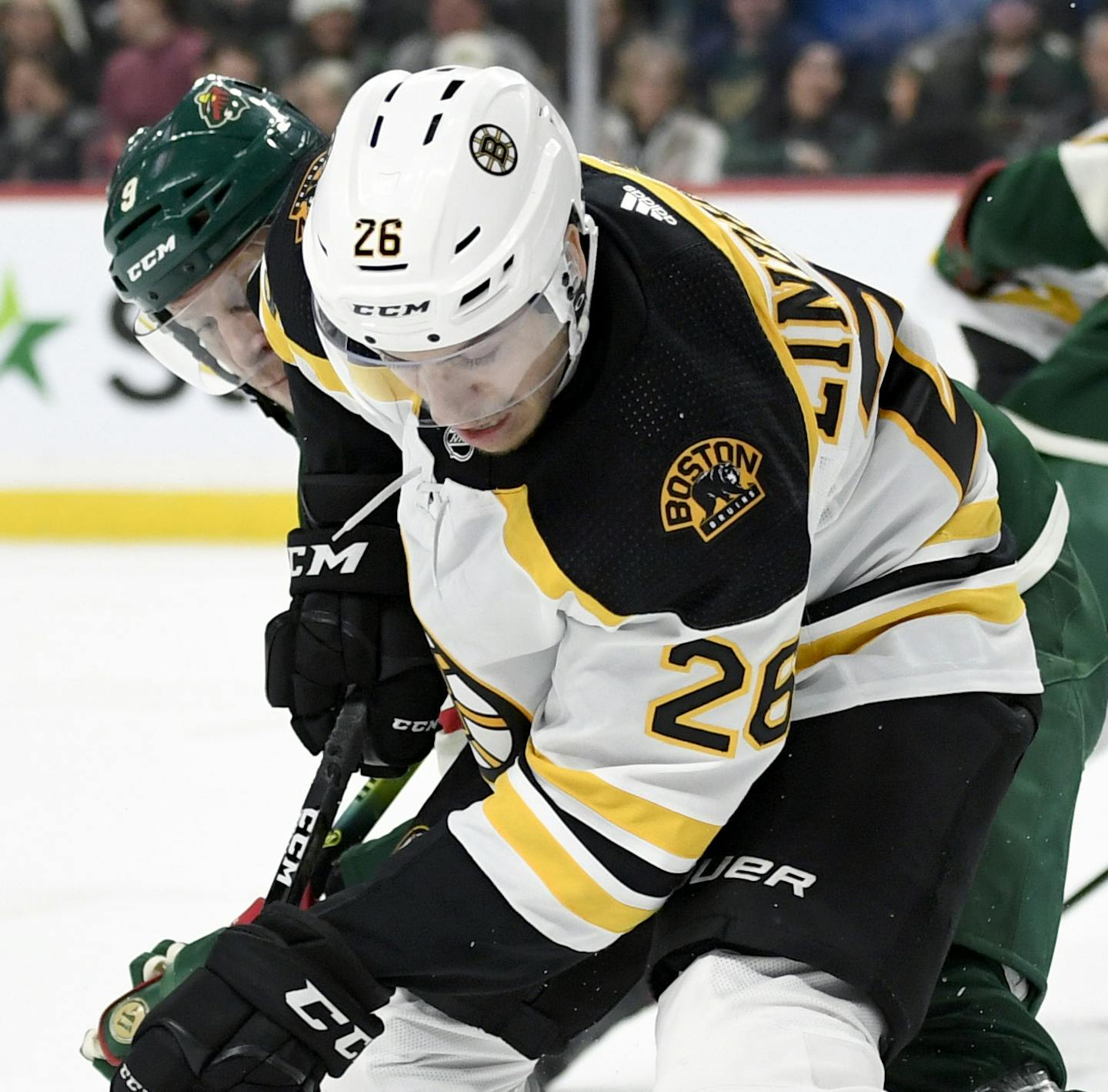 Boston Bruins' Par Lindholm (26), of Sweden, has the puck against Minnesota Wild's Mikko Koivu (9), of Finland, during the second period of an NHL hockey game Saturday, Feb. 1, 2020, in St. Paul, Minn. (AP Photo/Hannah Foslien)