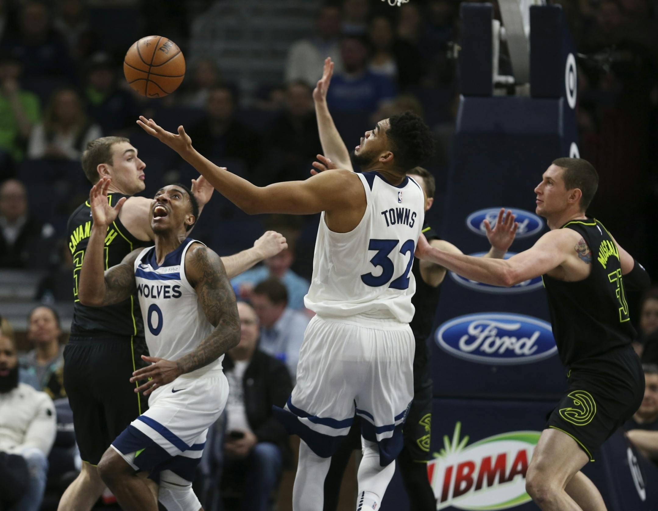 Minnesota Timberwolves center Karl-Anthony Towns (32) and guard Jeff Teague (0) eyed a loose ball between them in the first quarter.
