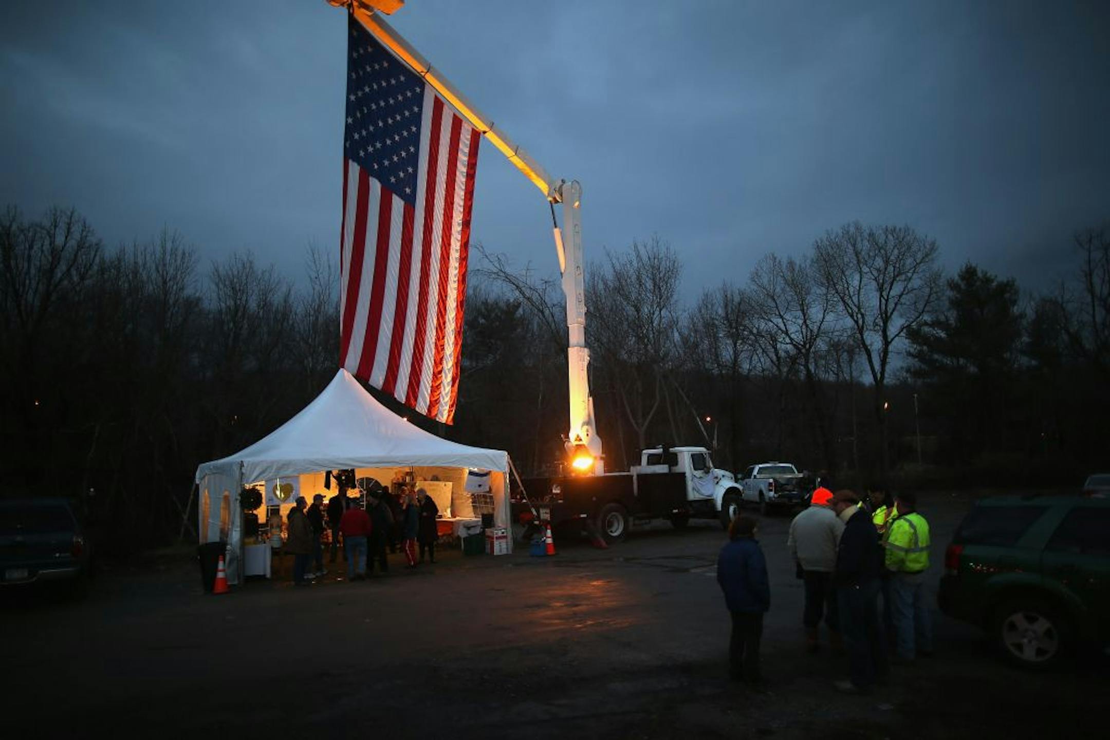 A flag hung over a memorial for the Sandy Hook shooting victims as two more of the slain first-graders were remembered at church services in Newtown, Conn. One church alone will hold funerals for eight of the victims over the coming days.