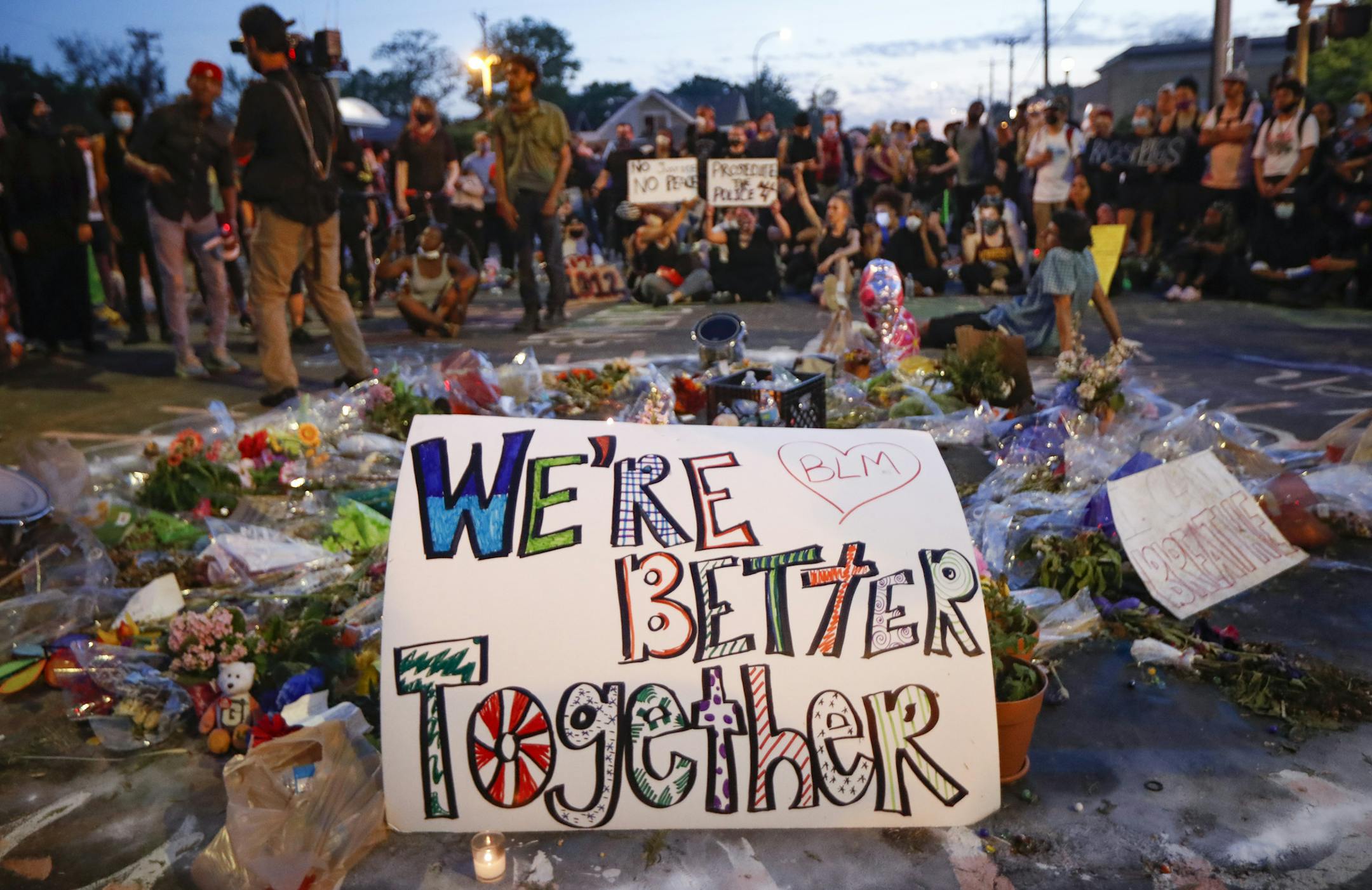 FILE - In this June 1, 2020, protesters gather at a memorial for George Floyd where he died outside Cup Foods on East 38th Street and Chicago Avenue in Minneapolis. A tough road lies ahead for President-elect Joe Biden who will need to chart a path forward to unite a bitterly divided nation and address America's fraught history of racism that manifested this year through the convergence of three national crises. (AP Photo/John Minchillo, File)